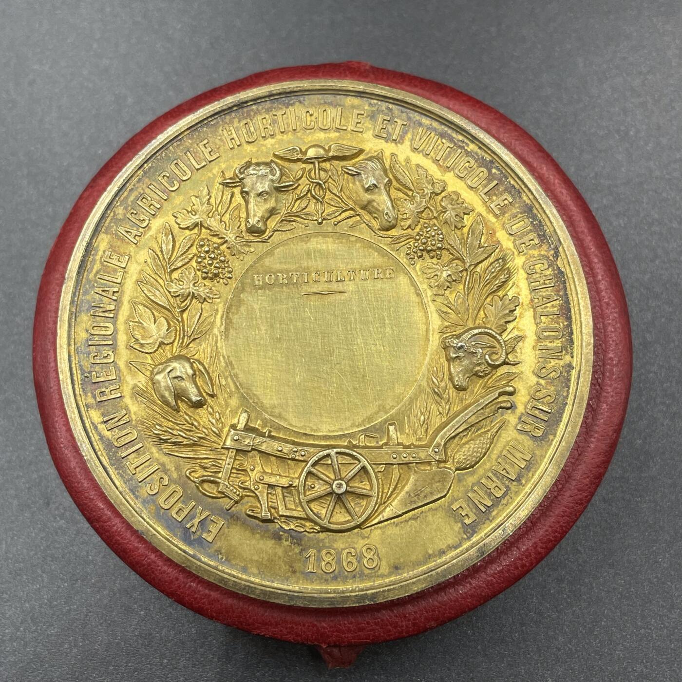 「木头集藏」“冬至雅藏”——章牌精品专场！ A.MERLEY.F～1868年法国马恩河畔沙隆地区农业、园艺与葡萄种植博览会原盒镀金大银章，直径：57.2 mm，88.2 g，边铭：蜜蜂 ARGENT，品相很不错，原盒正常扣合（打开略吃力），章面装饰有牛、马、羊等牲畜头雕，搭配葡萄藤、麦穗等农业元素，还有犁、车轮等农具图案，正中刻有“HORTICULTURE”（园艺），直观体现博览会聚焦农业、园艺与葡萄种植的主题。