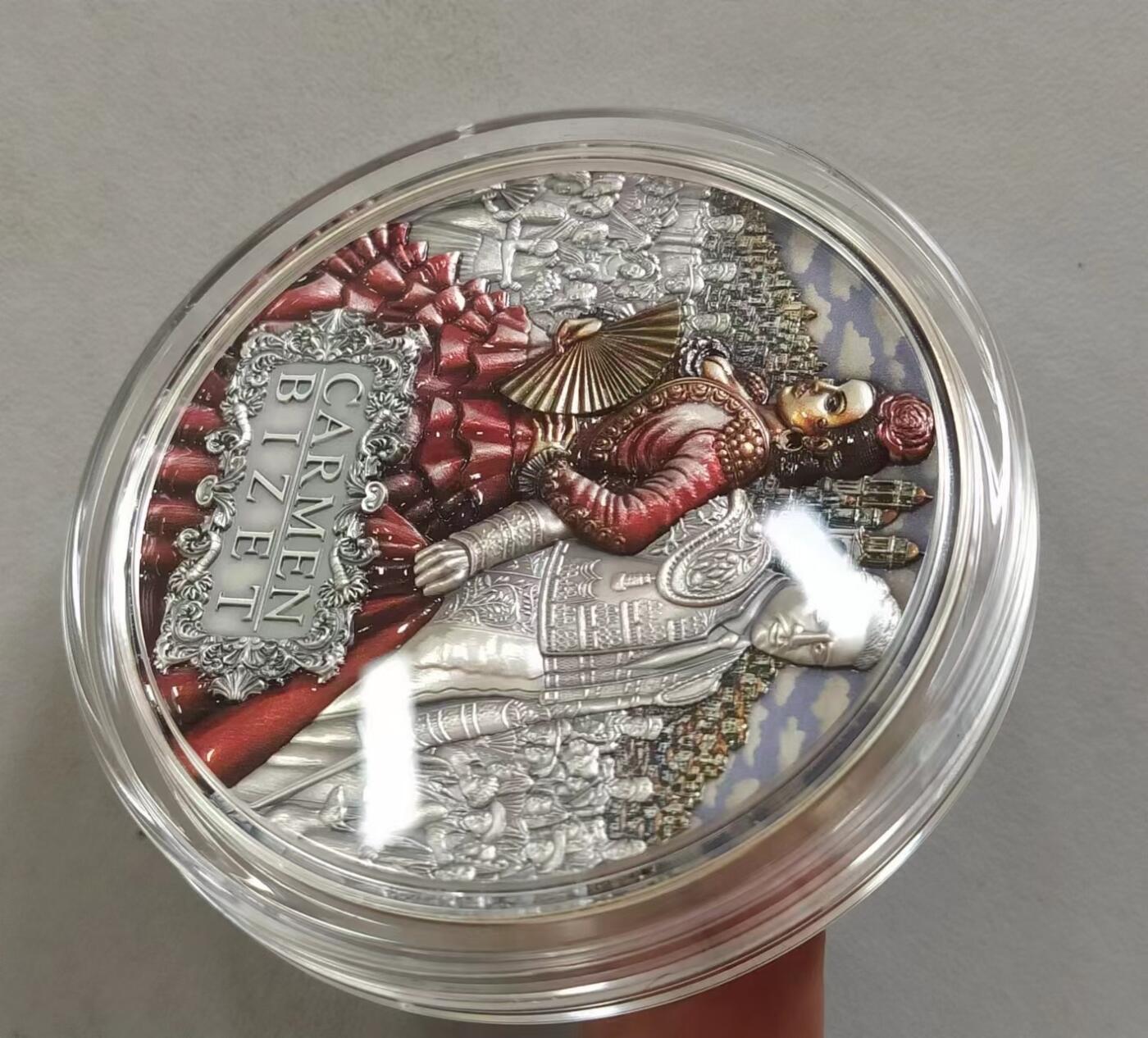 第185期拍卖 纽埃2022年，世界最著名(比才)歌剧《卡门》，2盎司加大(直径达55mm)，超高、超精浮雕, 仿古、全景、彩色银币. 盒证全. 遵照国际最高银币质量标准制造. 采用“全景”设计，人物与背景充满了画面，超高精细浮雕远、中、近景层次分明，工艺细致. 实物更加立体震撼,非常漂亮. 应景当前巴黎奥运会热门银币. 国外售价350美元