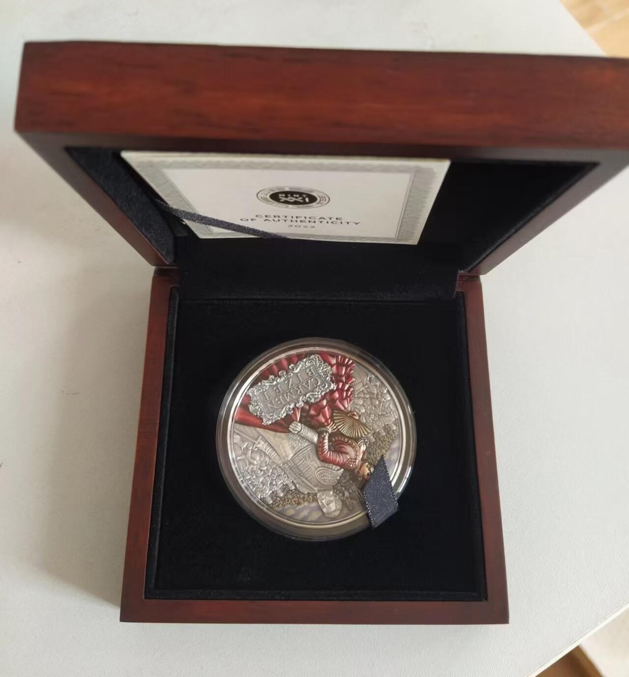 第185期拍卖 纽埃2022年，世界最著名(比才)歌剧《卡门》，2盎司加大(直径达55mm)，超高、超精浮雕, 仿古、全景、彩色银币. 盒证全. 遵照国际最高银币质量标准制造. 采用“全景”设计，人物与背景充满了画面，超高精细浮雕远、中、近景层次分明，工艺细致. 实物更加立体震撼,非常漂亮. 应景当前巴黎奥运会热门银币. 国外售价350美元