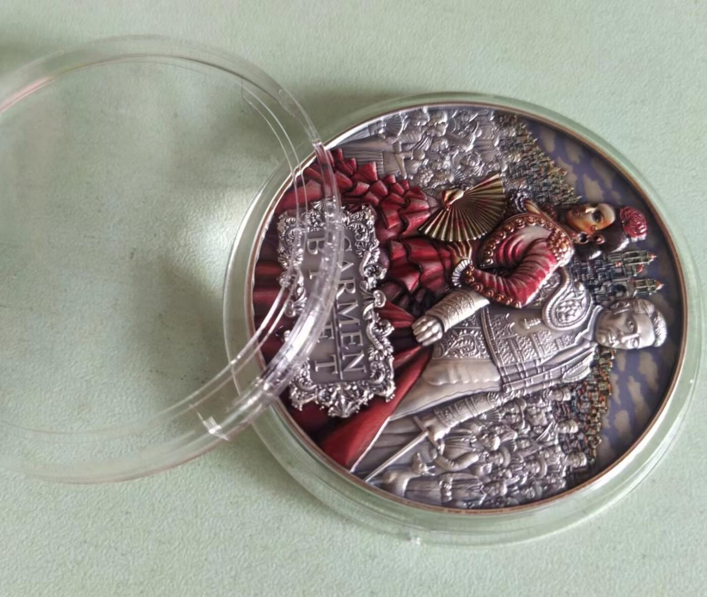 第185期拍卖 纽埃2022年，世界最著名(比才)歌剧《卡门》，2盎司加大(直径达55mm)，超高、超精浮雕, 仿古、全景、彩色银币. 盒证全. 遵照国际最高银币质量标准制造. 采用“全景”设计，人物与背景充满了画面，超高精细浮雕远、中、近景层次分明，工艺细致. 实物更加立体震撼,非常漂亮. 应景当前巴黎奥运会热门银币. 国外售价350美元