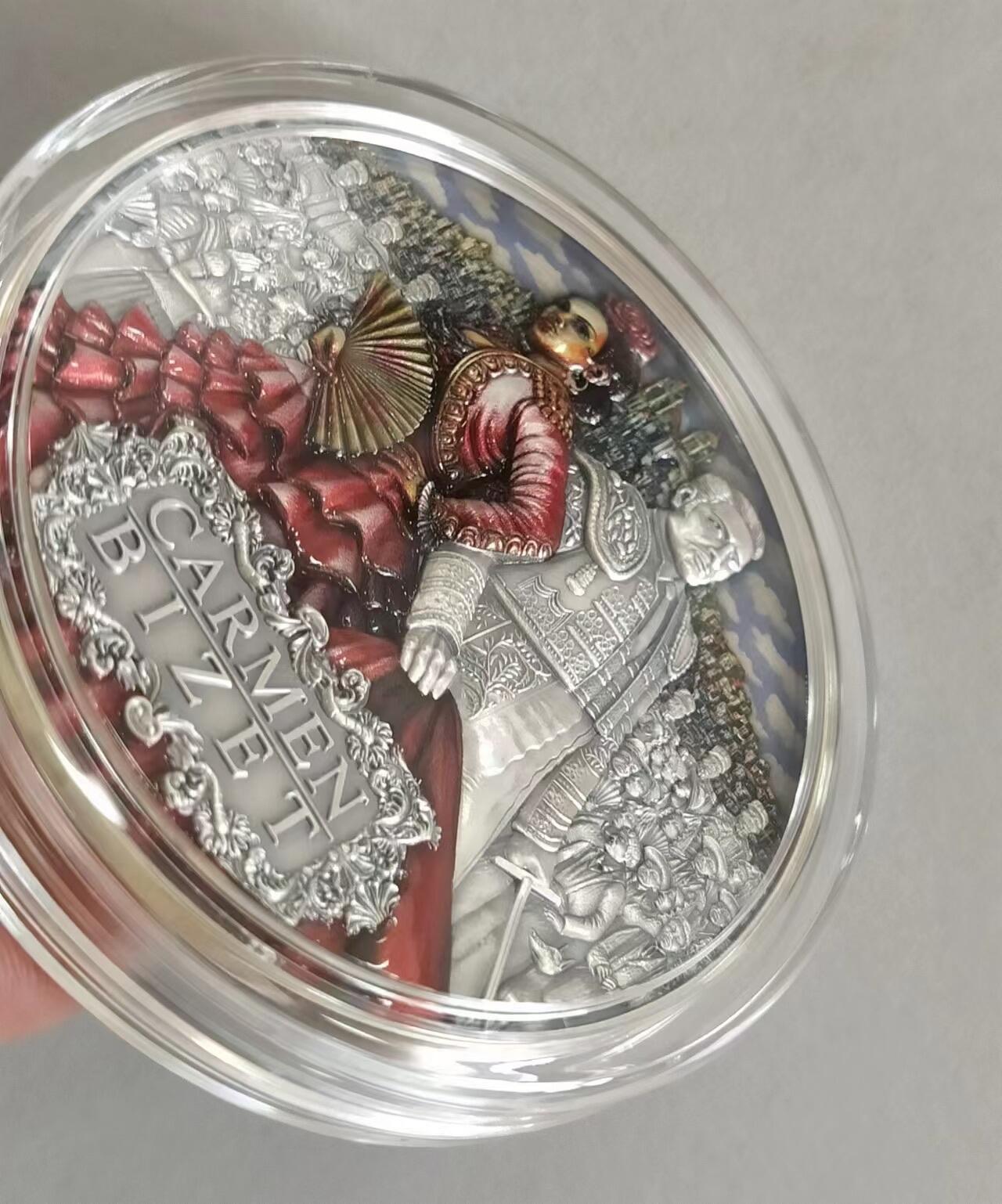 第185期拍卖 纽埃2022年，世界最著名(比才)歌剧《卡门》，2盎司加大(直径达55mm)，超高、超精浮雕, 仿古、全景、彩色银币. 盒证全. 遵照国际最高银币质量标准制造. 采用“全景”设计，人物与背景充满了画面，超高精细浮雕远、中、近景层次分明，工艺细致. 实物更加立体震撼,非常漂亮. 应景当前巴黎奥运会热门银币. 国外售价350美元