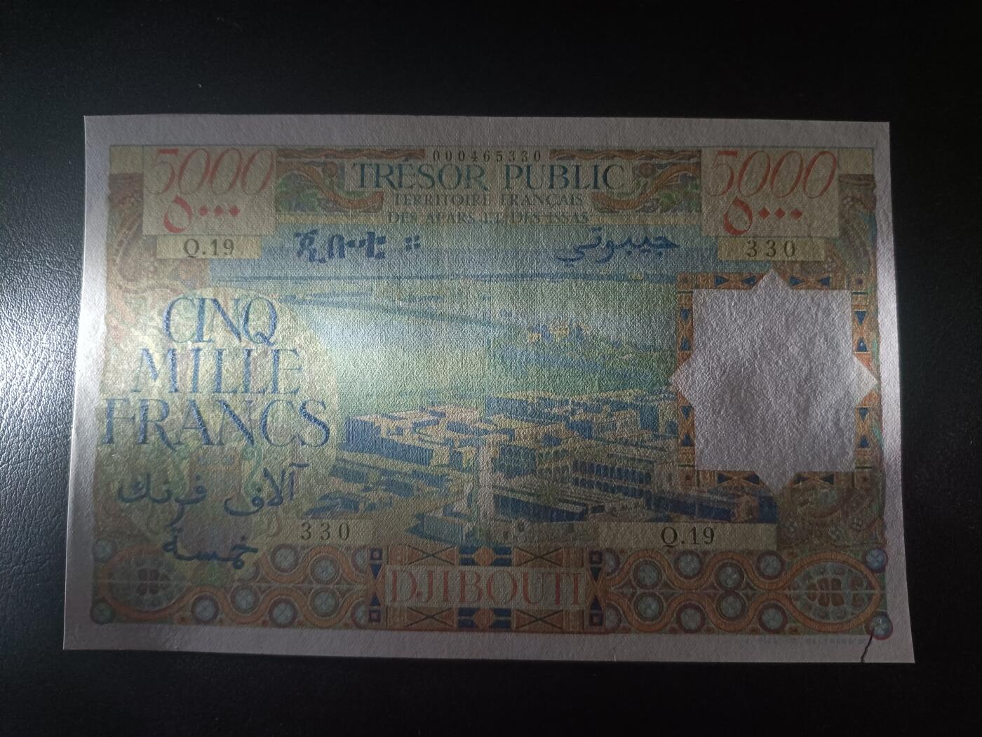 2025十二月第四期，总209期 法属阿法尔和伊萨斯（现吉布提）1969版5000法郎AUNC边不齐/裂口，作为稀有的最高面值，正面是吉布提的俯瞰图，而背面是本地特色建筑碉楼