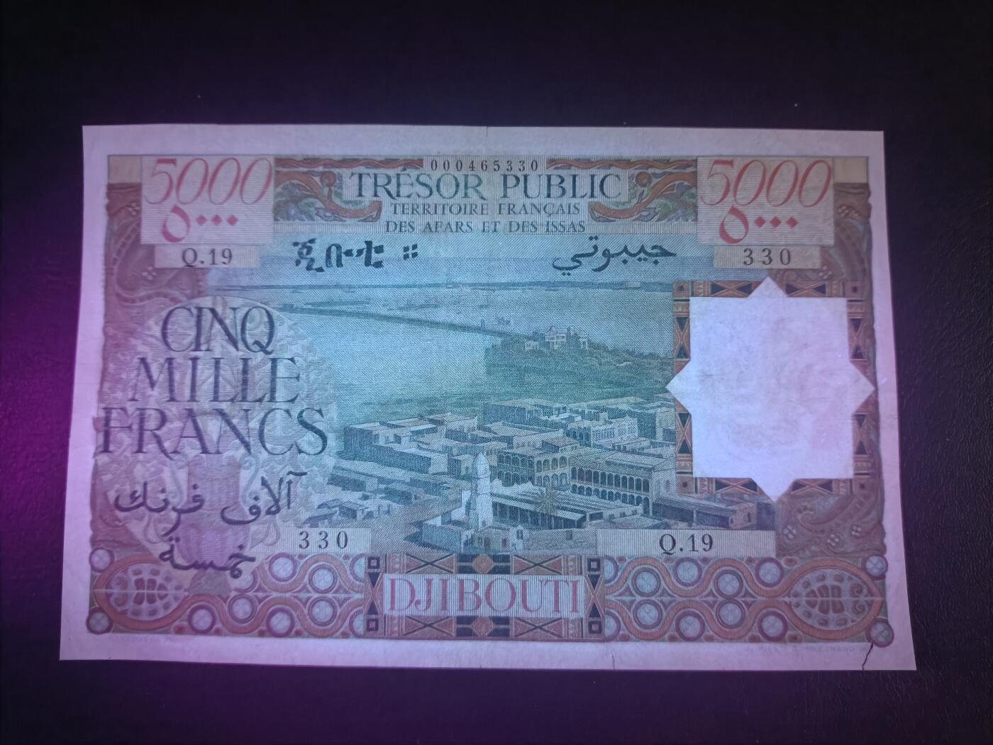 2025十二月第四期，总209期 法属阿法尔和伊萨斯（现吉布提）1969版5000法郎AUNC边不齐/裂口，作为稀有的最高面值，正面是吉布提的俯瞰图，而背面是本地特色建筑碉楼