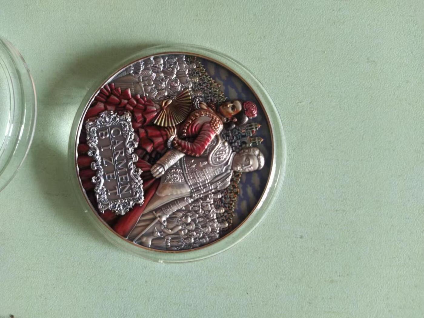 第185期拍卖 纽埃2022年，世界最著名(比才)歌剧《卡门》，2盎司加大(直径达55mm)，超高、超精浮雕, 仿古、全景、彩色银币. 盒证全. 遵照国际最高银币质量标准制造. 采用“全景”设计，人物与背景充满了画面，超高精细浮雕远、中、近景层次分明，工艺细致. 实物更加立体震撼,非常漂亮. 应景当前巴黎奥运会热门银币. 国外售价350美元