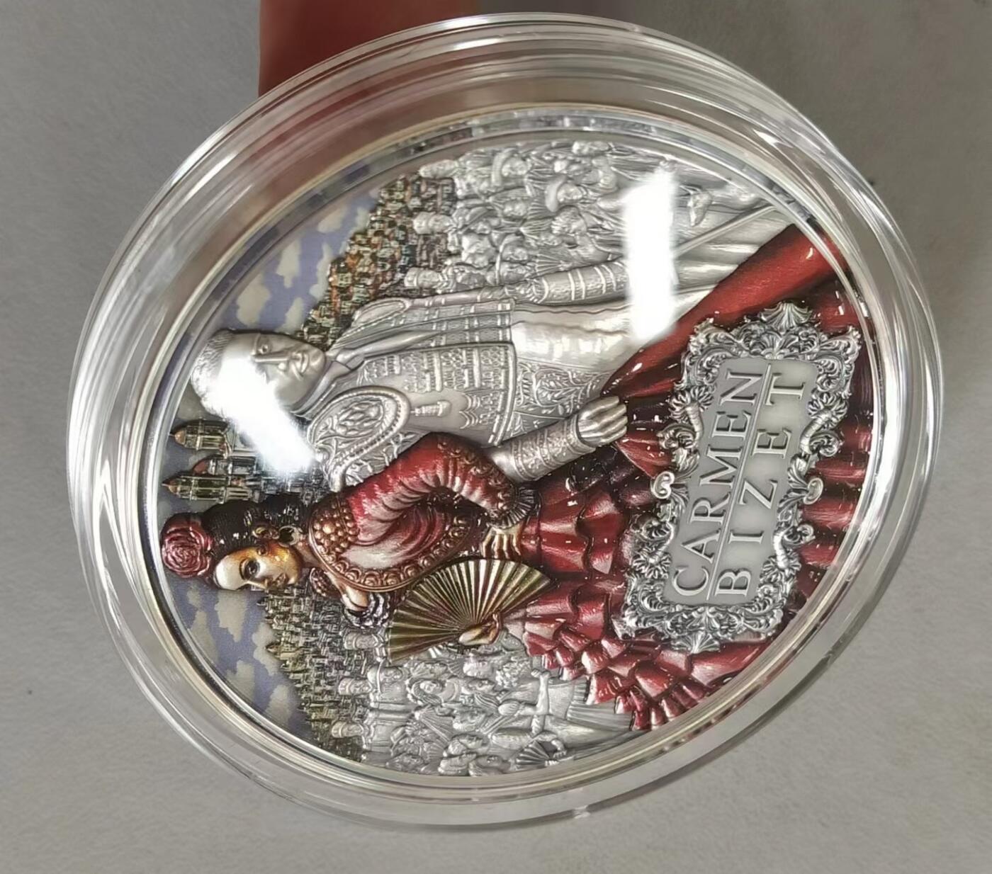 第185期拍卖 纽埃2022年，世界最著名(比才)歌剧《卡门》，2盎司加大(直径达55mm)，超高、超精浮雕, 仿古、全景、彩色银币. 盒证全. 遵照国际最高银币质量标准制造. 采用“全景”设计，人物与背景充满了画面，超高精细浮雕远、中、近景层次分明，工艺细致. 实物更加立体震撼,非常漂亮. 应景当前巴黎奥运会热门银币. 国外售价350美元