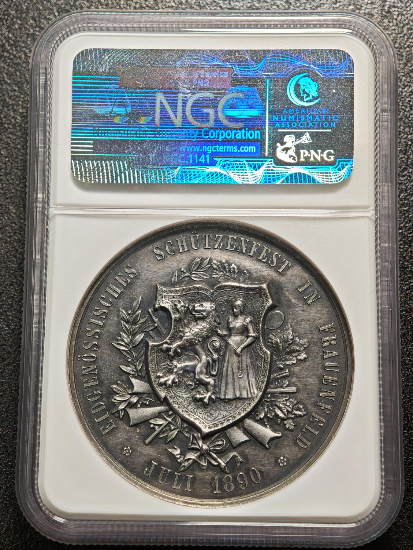 【德藏】世界币章拍卖第158期（拍品征集中~欢迎藏友联系） 1890年 瑞士劳恩菲尔德射击节高浮雕纪念大银章 NGC MS61 正面是两位女神，一位女神一手持剑一手高举盾牌，另一位女神坐着观看，姿态优雅；背面是射击节盾徽，盾徽中间是美女用绳索勒住狮子的脖子。双面高浮雕工艺，整体雕刻精美，人物动物细节丰富，保存状态很好，黑包浆醇厚，早期NGC低评