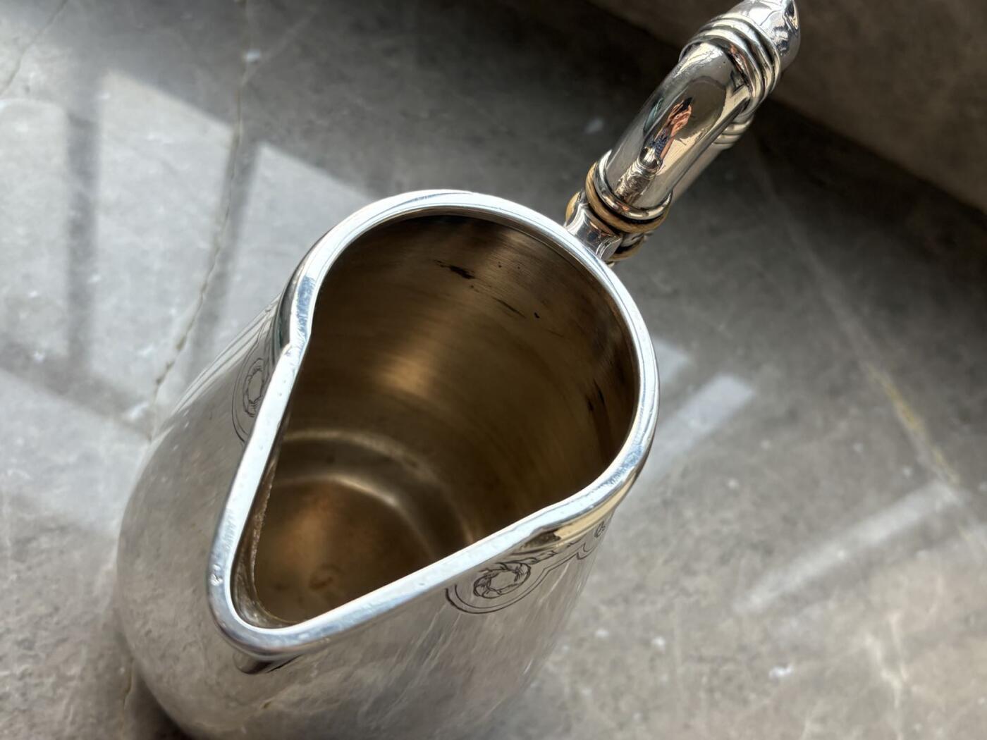 盛世勋华——号角文化勋章邮票专场拍卖第294期 意大利王国皇家海军1941年军官定制银壶，重989克，由米兰知名工坊Broggi打造，执壶通高220毫米（含把手），采用银制工艺打造（部分镀银），器身经精细錾刻与抛光处理，线条流畅饱满，呈现出优雅的梨形轮廓。壶身饰有意大利皇家海军专属纹章与航海主题装饰纹样，底座有银标和厂标