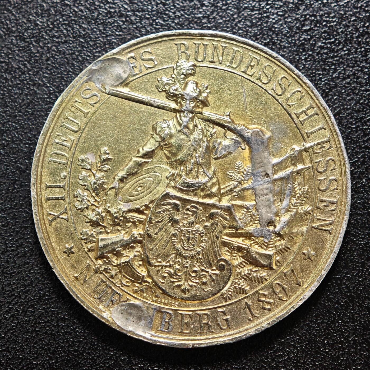 【德藏】世界币章拍卖第158期（拍品征集中~欢迎藏友联系） 1897年 德国纽伦堡第十二届联邦射击节镀金纪念银章(有焊点去除) 该属于德意志帝国时期重要的射击赛事纪念章，由德国造币机构铸造，用以纪念当年在纽伦堡举办的联邦射击节盛会 德国联邦射击节（Bundesschiessen）始于1861年，是德意志地区规模最大的射击赛事，兼具军事训练与民间体育属性，1897年纽伦堡举办的第十二届赛事是德意志帝国时期的重要体育盛会 直径约：40.3mm；重约：29.4g