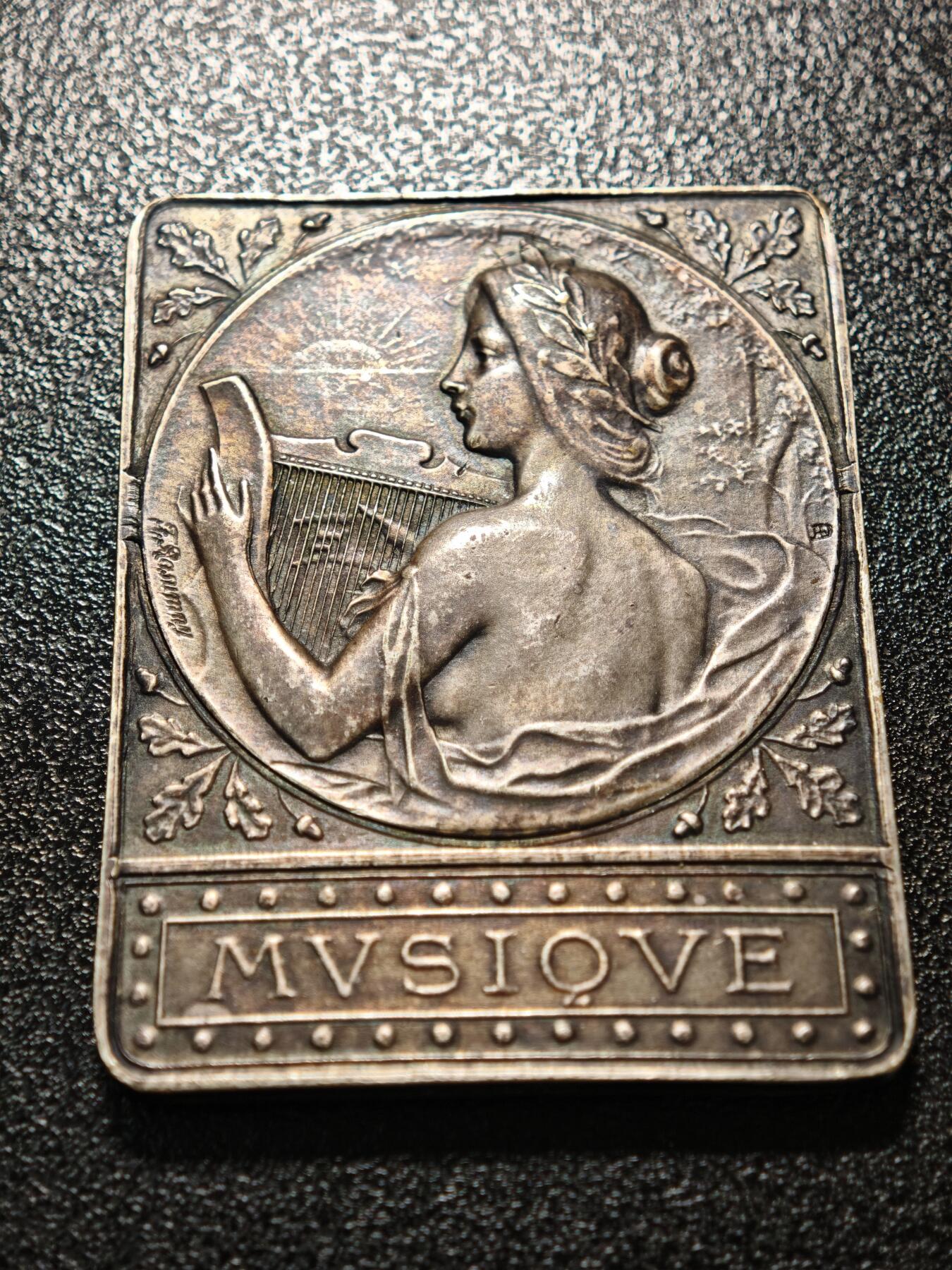 【德藏】世界币章拍卖第158期（拍品征集中~欢迎藏友联系） 1909年 法国塞纳河畔罗米利音乐主题矩形镀银纪念章 由法国新艺术时期铸章师设计打造，是为当地音乐活动颁发的荣誉表彰牌 塞纳河畔罗米利（Romilly-sur-Seine）是法国香槟-阿登地区的城市，1909年当地举办音乐赛事或庆典活动，此纪念牌作为荣誉奖品颁发给优秀的音乐从业者/参赛者，是法国地方文化艺术活动的实物见证 深五彩包浆 直径约：39.4mm×50mm；重约：44.1g