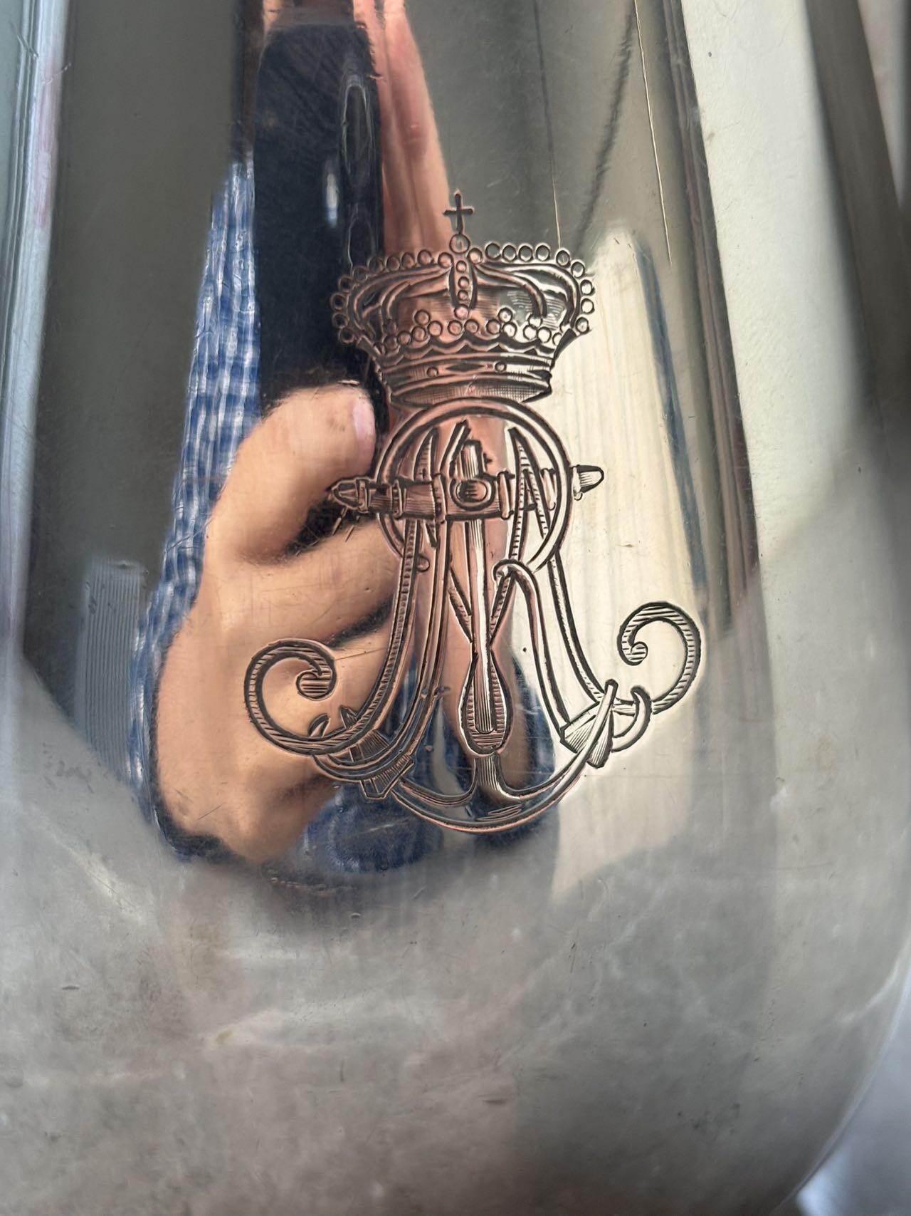 盛世勋华——号角文化勋章邮票专场拍卖第294期 意大利王国皇家海军1941年军官定制银壶，重989克，由米兰知名工坊Broggi打造，执壶通高220毫米（含把手），采用银制工艺打造（部分镀银），器身经精细錾刻与抛光处理，线条流畅饱满，呈现出优雅的梨形轮廓。壶身饰有意大利皇家海军专属纹章与航海主题装饰纹样，底座有银标和厂标