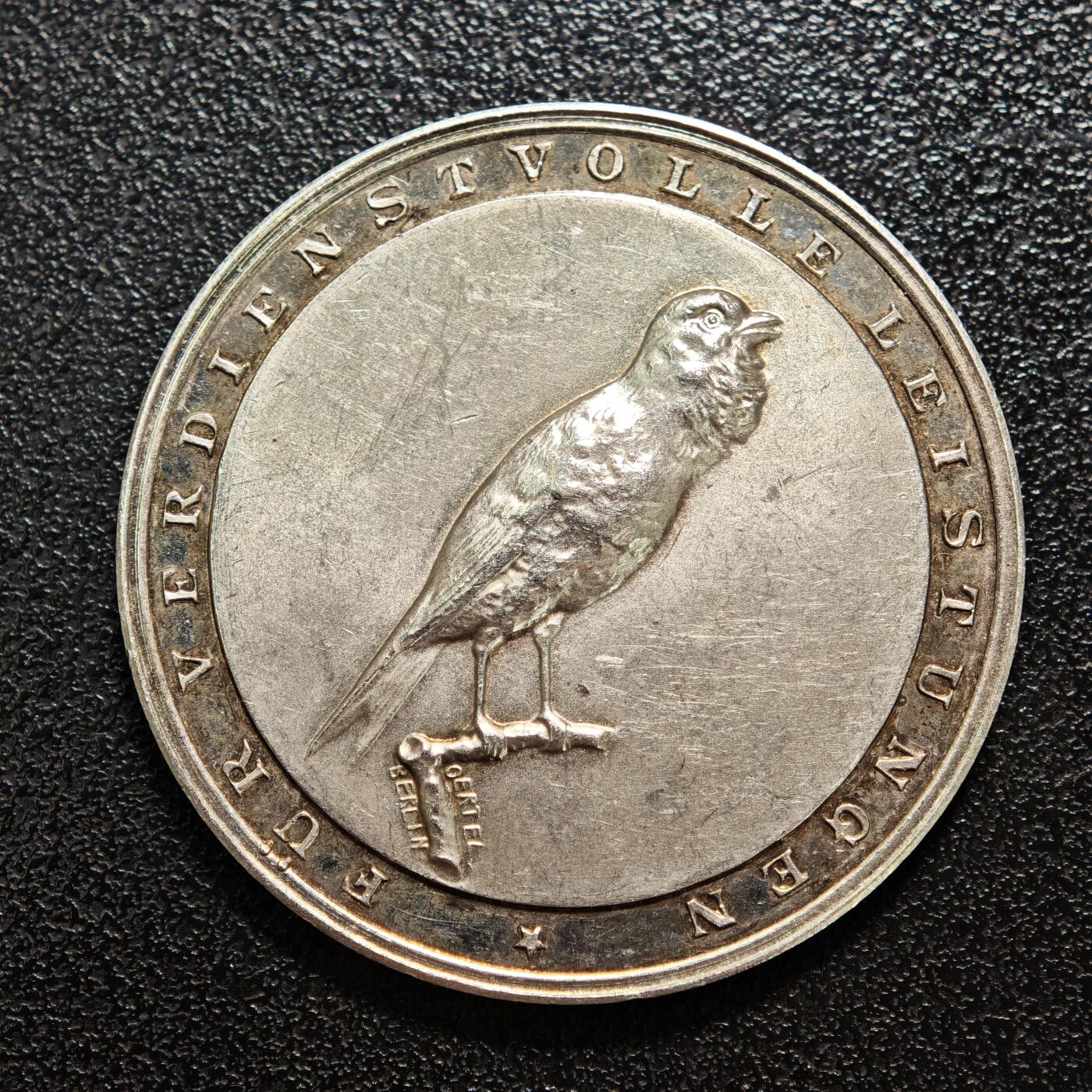 【德藏】世界币章拍卖第158期（拍品征集中~欢迎藏友联系） 1928年 德国金丝雀饲养者协会荣誉奖章纪念银章 由德国造币机构铸造，是该协会为表彰金丝雀繁育领域杰出贡献者颁发的荣誉奖章 德国是欧洲金丝雀繁育的核心地区之一，19世纪起形成专业的饲养者协会，聚焦金丝雀的品种培育、鸣唱训练等领域，这类奖章是行业内认可繁育者成就的重要凭证 直径约：35.2mm；重约：17.3g