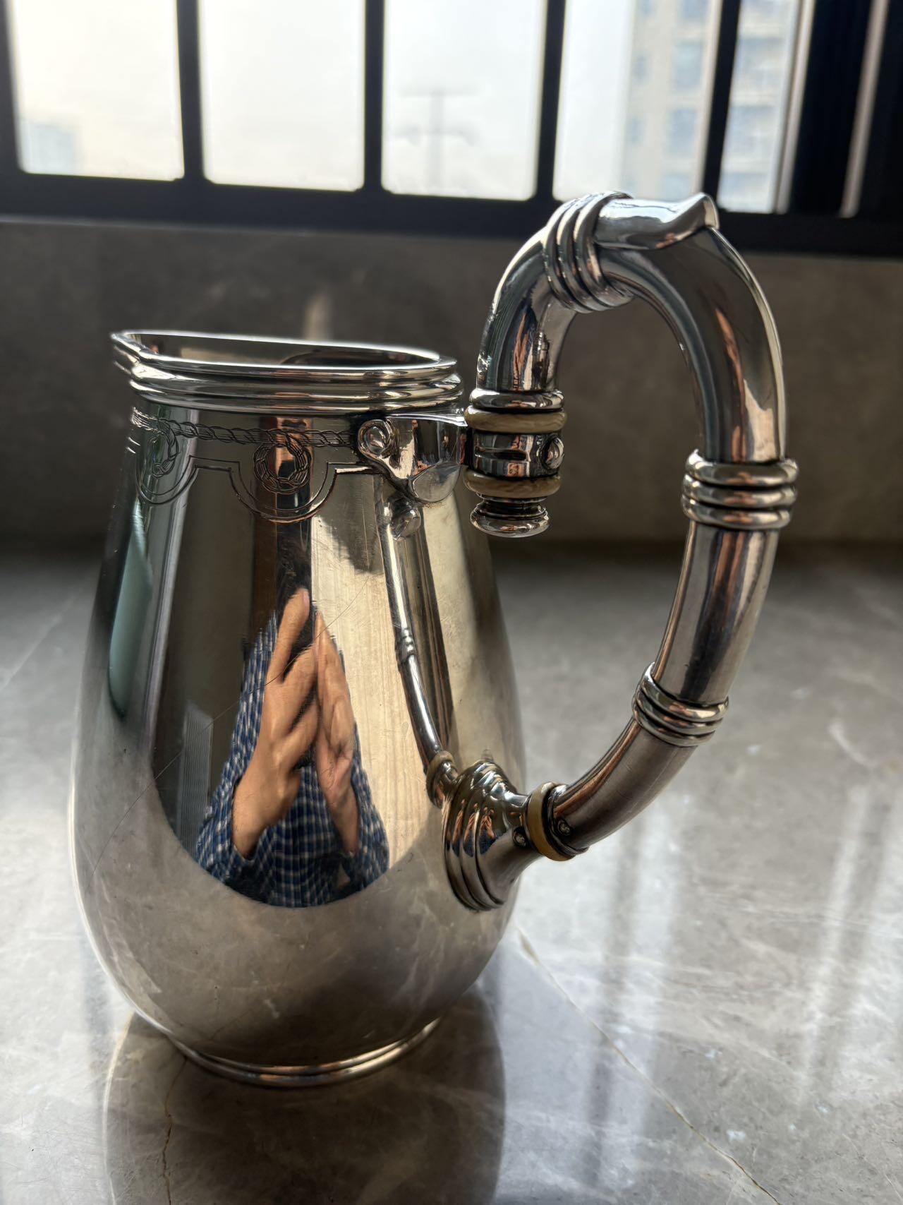 盛世勋华——号角文化勋章邮票专场拍卖第294期 意大利王国皇家海军1941年军官定制银壶，重989克，由米兰知名工坊Broggi打造，执壶通高220毫米（含把手），采用银制工艺打造（部分镀银），器身经精细錾刻与抛光处理，线条流畅饱满，呈现出优雅的梨形轮廓。壶身饰有意大利皇家海军专属纹章与航海主题装饰纹样，底座有银标和厂标