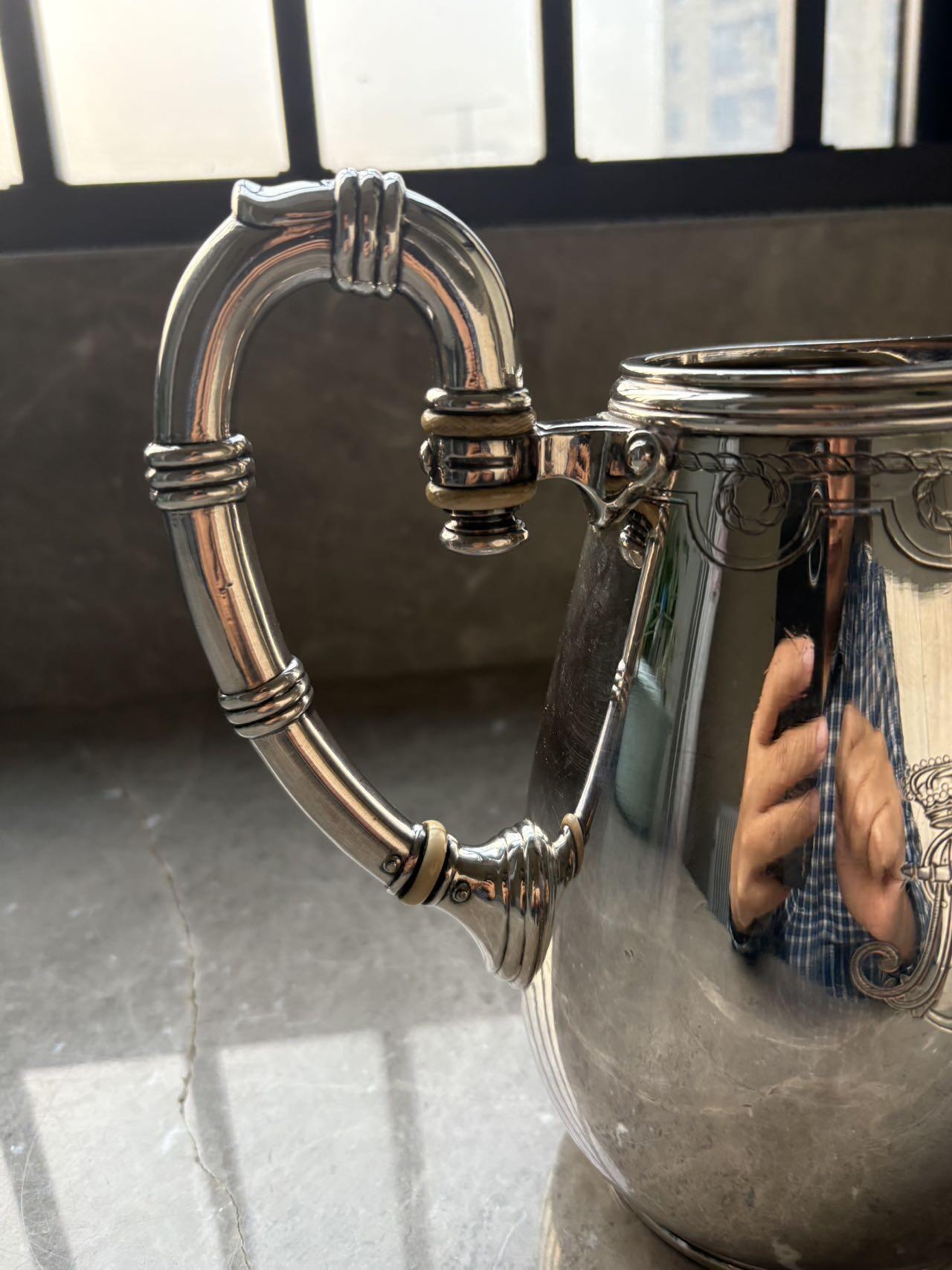 盛世勋华——号角文化勋章邮票专场拍卖第294期 意大利王国皇家海军1941年军官定制银壶，重989克，由米兰知名工坊Broggi打造，执壶通高220毫米（含把手），采用银制工艺打造（部分镀银），器身经精细錾刻与抛光处理，线条流畅饱满，呈现出优雅的梨形轮廓。壶身饰有意大利皇家海军专属纹章与航海主题装饰纹样，底座有银标和厂标