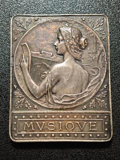 【德藏】世界币章拍卖第158期 - 1909年 法国塞纳河畔罗米利音乐主题矩形镀银纪念章 由法国新艺术时期铸章师设计打造，是为当地音乐活动颁发的荣誉表彰牌 塞纳河畔罗米利（Romilly-sur-Seine）是法国香槟-阿登地区的城市，1909年当地举办音乐赛事或庆典活动，此纪念牌作为荣誉奖品颁发给优秀的音乐从业者/参赛者，是法国地方文化艺术活动的实物见证 深五彩包浆 直径约：39.4mm×50mm；重约：44.1g