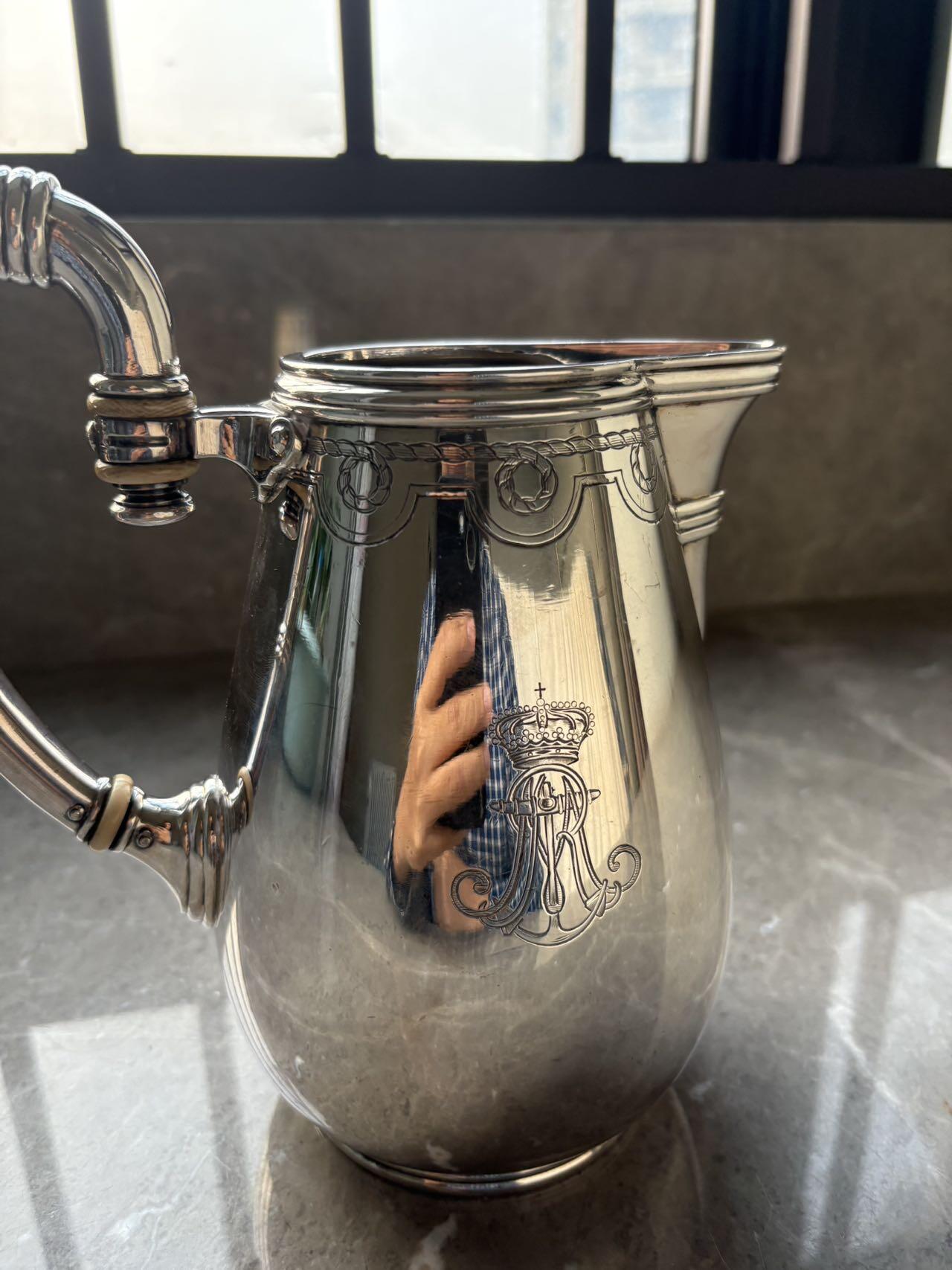 盛世勋华——号角文化勋章邮票专场拍卖第294期 意大利王国皇家海军1941年军官定制银壶，重989克，由米兰知名工坊Broggi打造，执壶通高220毫米（含把手），采用银制工艺打造（部分镀银），器身经精细錾刻与抛光处理，线条流畅饱满，呈现出优雅的梨形轮廓。壶身饰有意大利皇家海军专属纹章与航海主题装饰纹样，底座有银标和厂标