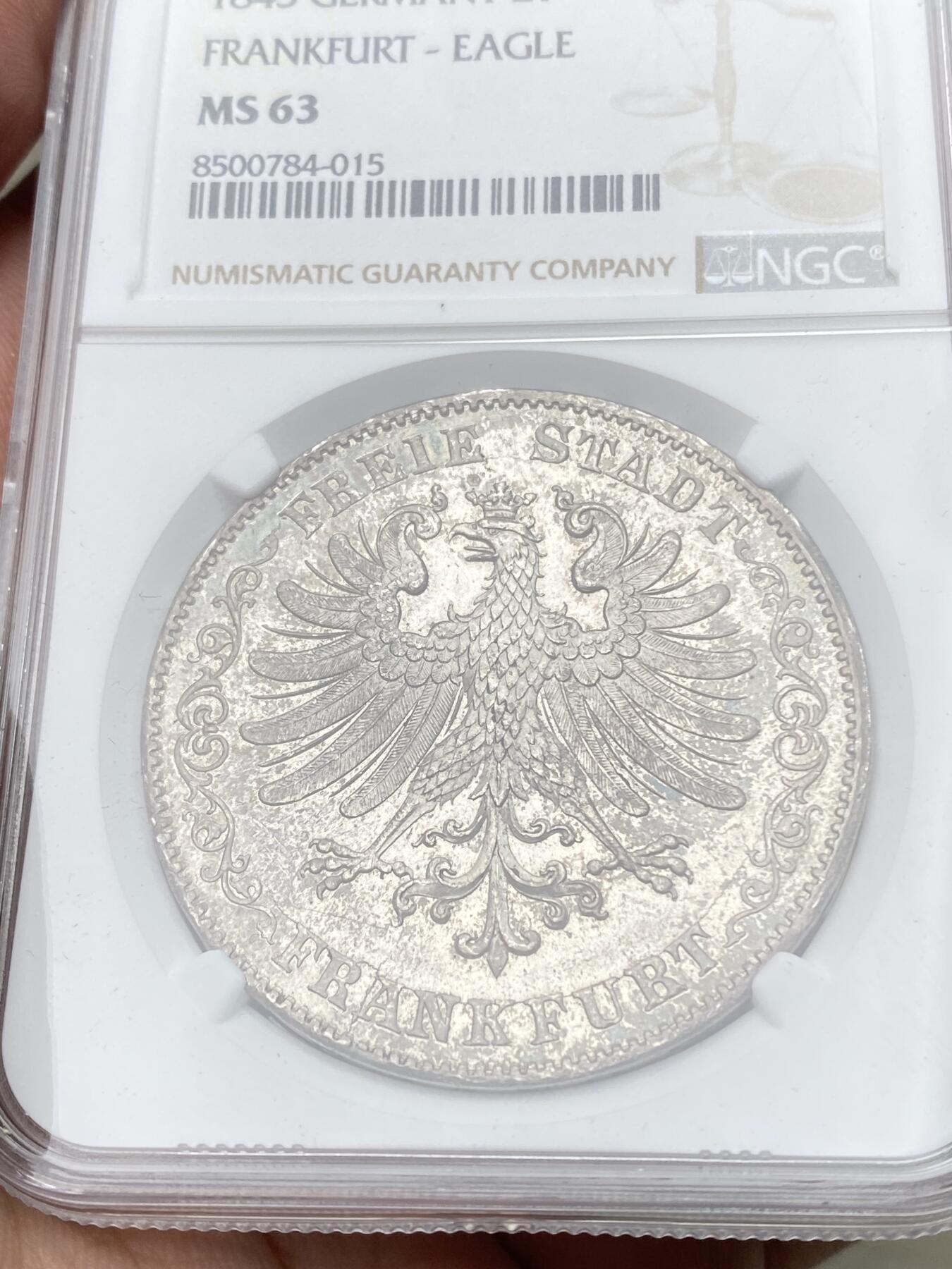 万国钱币拍卖第058期（万国新年大拍） NGC MS63 1843年法兰克福自由市鹰徽流通2泰勒 仅发行12万枚且流通充分 正面是象征法兰克福的雄鹰 背面橡叶结合面值 隔着盒子也能感受到其锋利打制的割手感 华丽淡彩转光 观感超越分数的顶级典藏品质