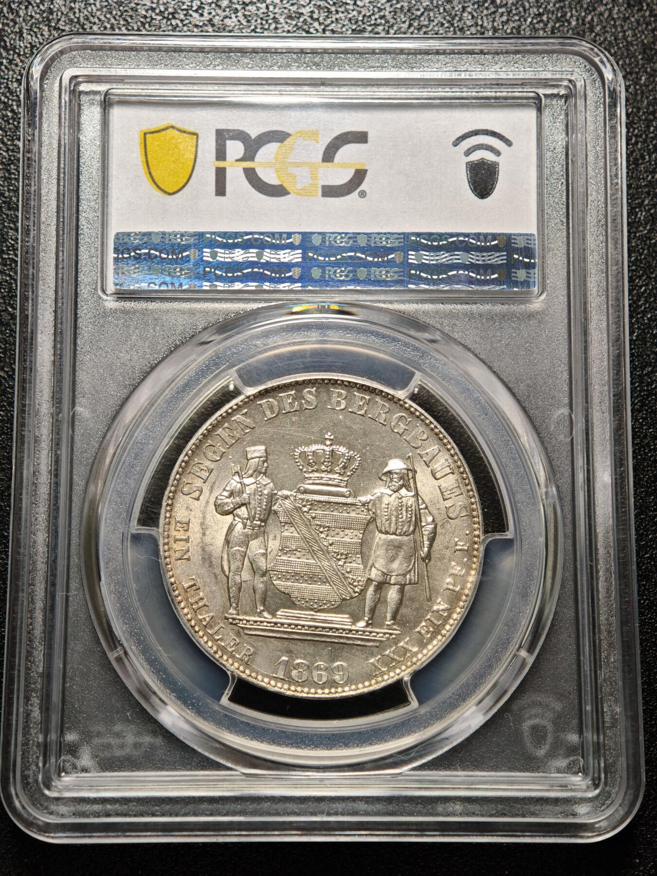 【德藏】世界币章拍卖第158期（拍品征集中~欢迎藏友联系） 1869年 德国萨克森约翰一世矿业祝福泰勒银币 PCGS MS62 淡黄油包浆 转光十足 萨克森是19世纪德国重要的矿业与冶金中心，银、锡、铁等矿产资源的开采与加工是其经济支柱，约翰一世时期发行此币，既是对矿业产业的致敬，也彰显了萨克森的经济特色