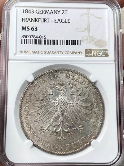 万国钱币拍卖第058期（万国新年大拍） - NGC MS63 1843年法兰克福自由市鹰徽流通2泰勒 仅发行12万枚且流通充分 正面是象征法兰克福的雄鹰 背面橡叶结合面值 隔着盒子也能感受到其锋利打制的割手感 华丽淡彩转光 观感超越分数的顶级典藏品质