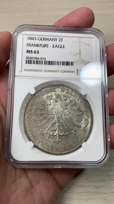 万国钱币拍卖第058期（万国新年大拍） NGC MS63 1843年法兰克福自由市鹰徽流通2泰勒 仅发行12万枚且流通充分 正面是象征法兰克福的雄鹰 背面橡叶结合面值 隔着盒子也能感受到其锋利打制的割手感 华丽淡彩转光 观感超越分数的顶级典藏品质