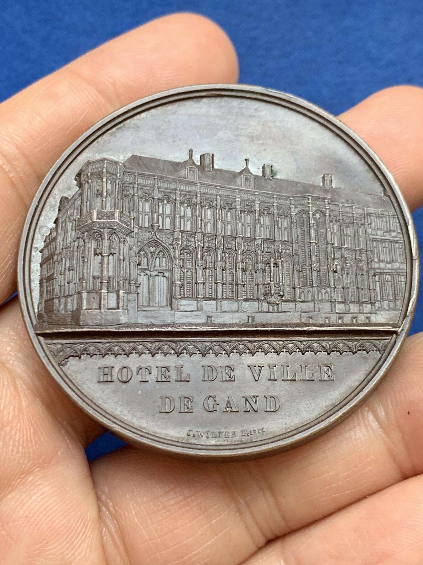 《竞宝斋》第449场 周日，周一，周二  3场连拍 （全场包邮，欢迎送拍） 比利时利奥波德一世国王加冕25周年纪念铜章，正面为根特城市建筑，以高浮雕形式呈现了它的立面，极丰富的细节展示当时雕刻工艺的极致状态，49.6克，50.3mm