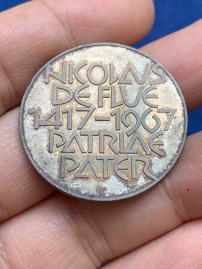 《竞宝斋》第449场 周日，周一，周二  3场连拍 （全场包邮，欢迎送拍） 尼古拉·德·弗吕逝世550周年纪念银章，他是15世纪瑞士宗教与政治人物，以调解瑞士邦联内部分裂、促成《施坦斯和约》而闻名，被尊为“祖国之父”。15.05克，32.8mm，900银