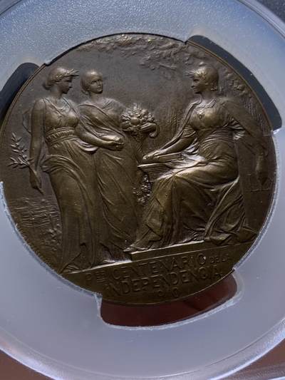 《竞宝斋》第449场 周日，周一，周二  3场连拍 （全场包邮，欢迎送拍） PCGS SP64 高分 阿根廷1910年百年独立共和国清凉女神大奖章。正面：清凉女神手托旗帜，手握锁链、头戴自由帽呐喊向前裸奔；背面：三女神像，鲜花、橄榄枝、书。PCGS加大盒装。