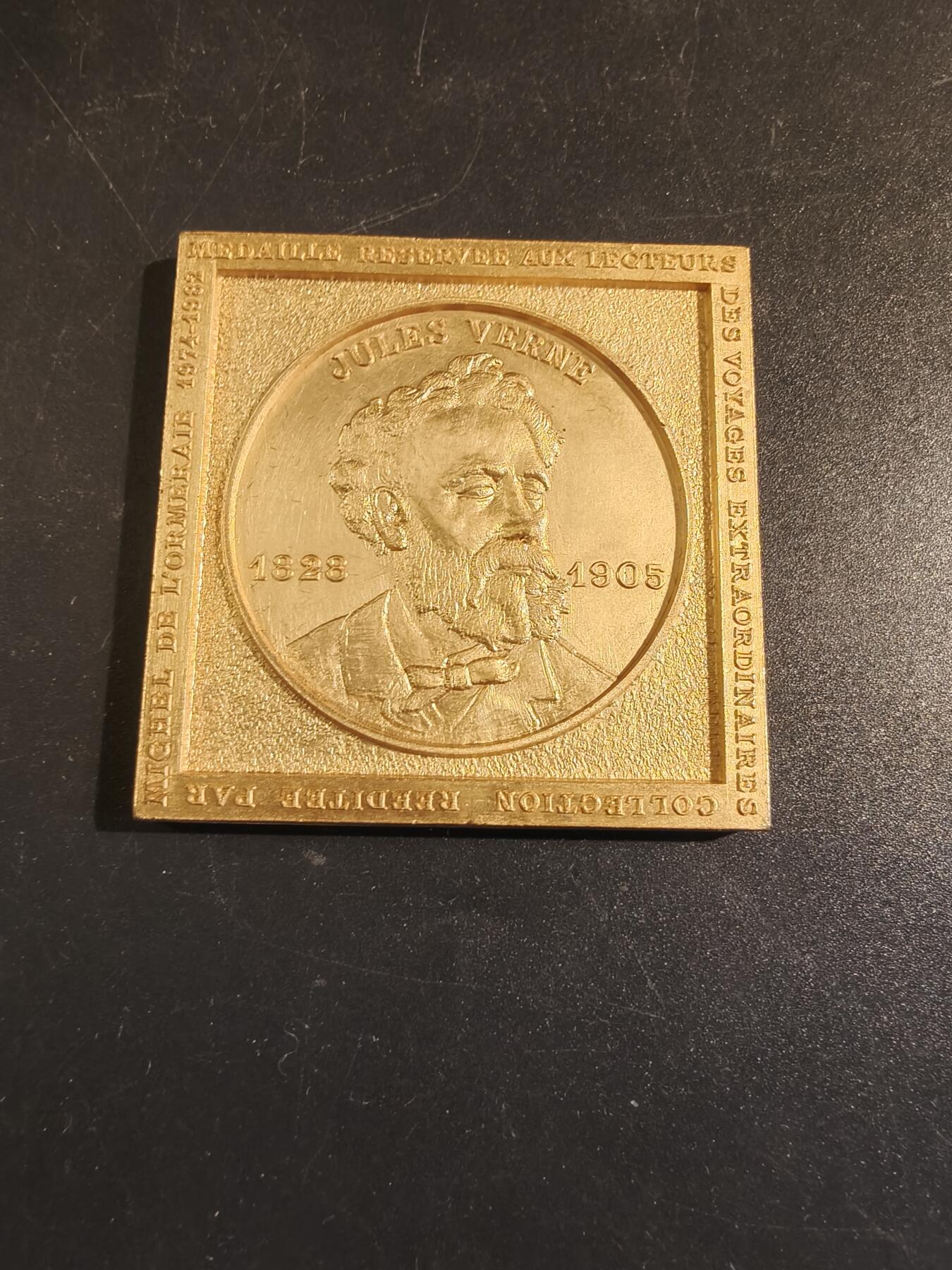 老王徽章第171期 法国存托银行与公证人协会镀金方形纪念章    原盒      直径50mm    重量50g     正面人物是法国著名文学家儒勒斯·凡尔纳。