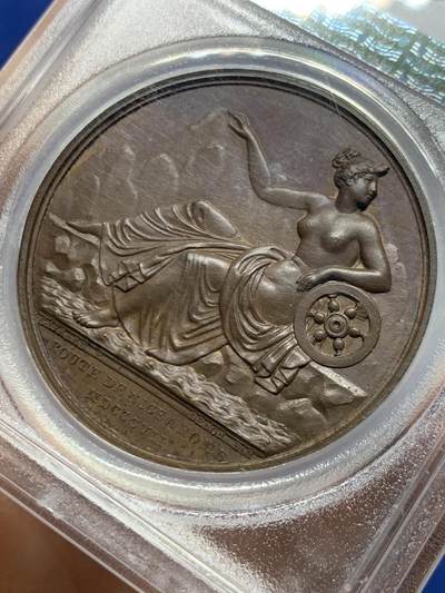 《竞宝斋》第449场 周日，周一，周二  3场连拍 （全场包邮，欢迎送拍） PCGS SP64 法国1807年拿破仑一世尼斯至罗马之路竣工原铸铜章 巴黎造币厂巧克力包浆 高浮雕原铸铜光 女神维比莉娅（罗马旅行女神）半倚着靠在六辐轮上，一只脚踩在岩石上，另一只脚踩在海面上，轻抬手臂，指明罗马的方向，脚下是罗马道路，背景是群山，画面唯美，条条大道通罗马的实际表现，欧洲最早的“高速公路”通车，标志着拿皇的统治从法国延伸至意大利，辐射整个欧陆。加厚盒