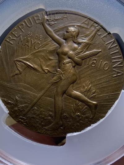 《竞宝斋》第449场 周日，周一，周二  3场连拍 （全场包邮，欢迎送拍） PCGS SP64 高分 阿根廷1910年百年独立共和国清凉女神大奖章。正面：清凉女神手托旗帜，手握锁链、头戴自由帽呐喊向前裸奔；背面：三女神像，鲜花、橄榄枝、书。PCGS加大盒装。