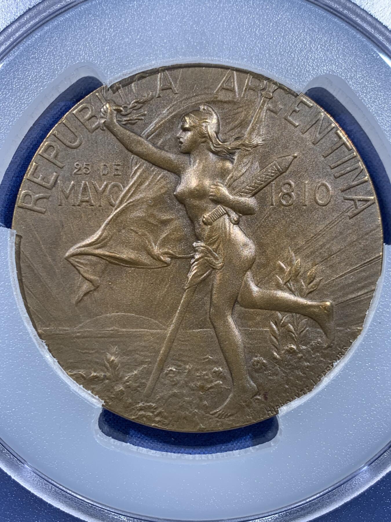 《竞宝斋》第449场 周日，周一，周二  3场连拍 （全场包邮，欢迎送拍） PCGS SP64 高分 阿根廷1910年百年独立共和国清凉女神大奖章。正面：清凉女神手托旗帜，手握锁链、头戴自由帽呐喊向前裸奔；背面：三女神像，鲜花、橄榄枝、书。PCGS加大盒装。