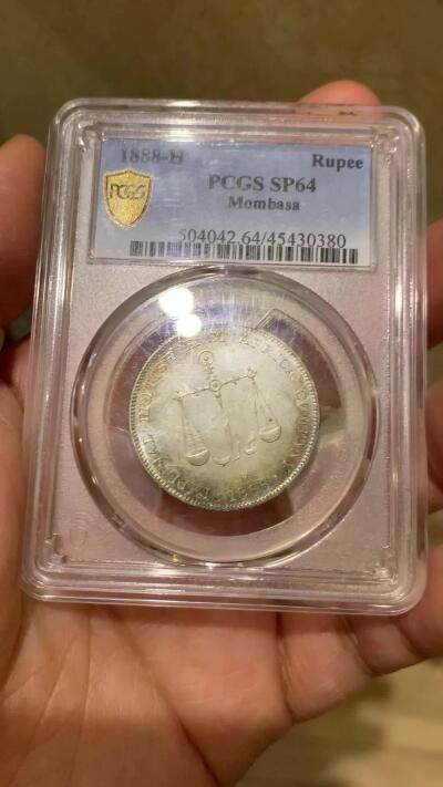 《竞宝斋》第449场 周日，周一，周二  3场连拍 （全场包邮，欢迎送拍） PCGS SP64 蒙巴萨 1888年1卢比银币 PL底板 绚丽五彩包浆 可与不求的状态 蒙巴萨是肯尼亚最大的港口，郑和下西洋最远到达的地方，大热门，吉祥年份 背面支撑小磕