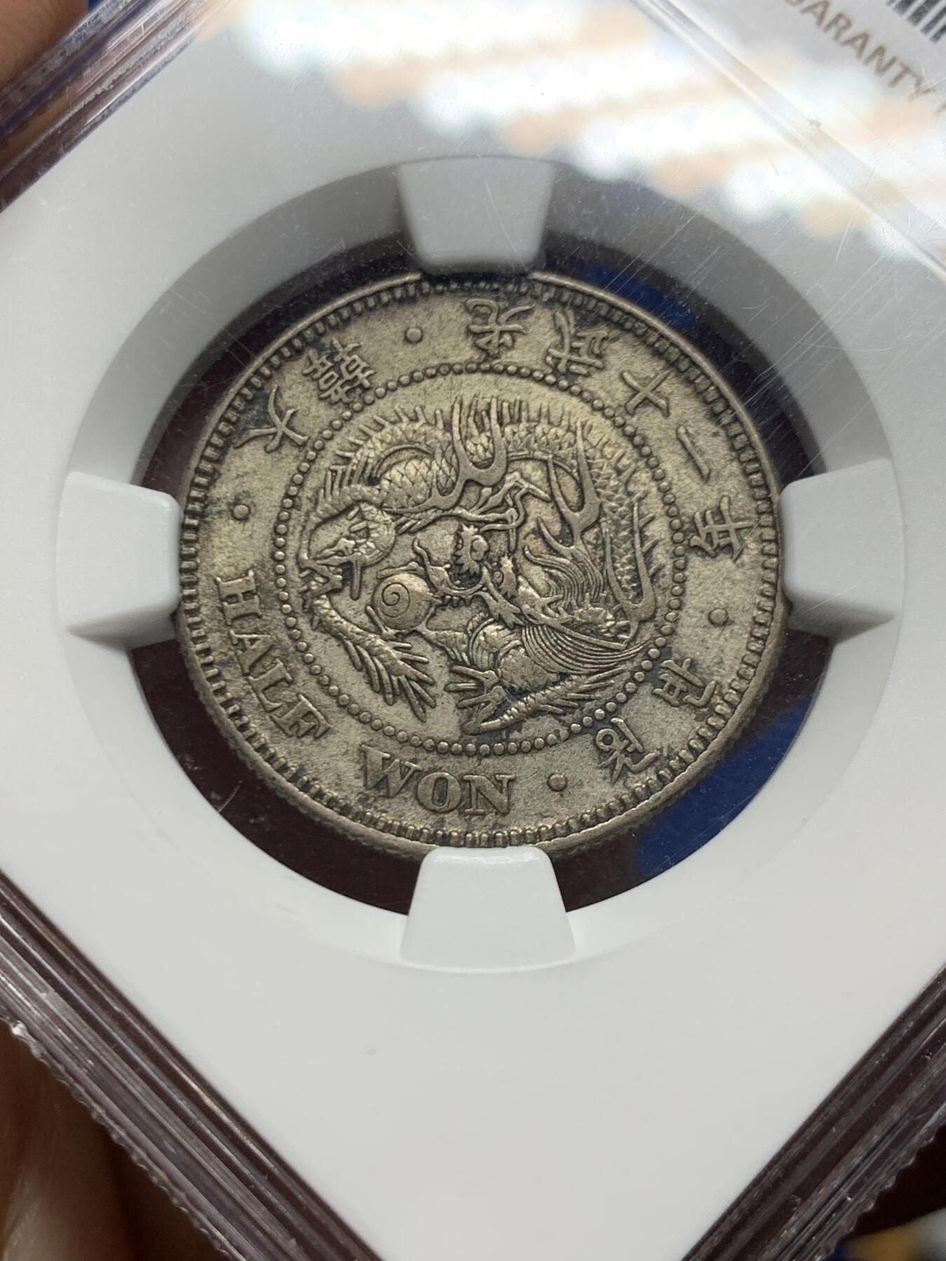 《竞宝斋》第450场 周日，周一，周二  3场连拍 （全场包邮，欢迎送拍） NGC AU53  朝鲜1907年光武十一年半圆银币 十一年稀少年份 原味自然老彩，正面蟠龙戏珠图，龙身盘踞如环，背面上方为“李花章”（五瓣木槿花），下方交叉的桔梗花（左）与李花（右），些许低评。