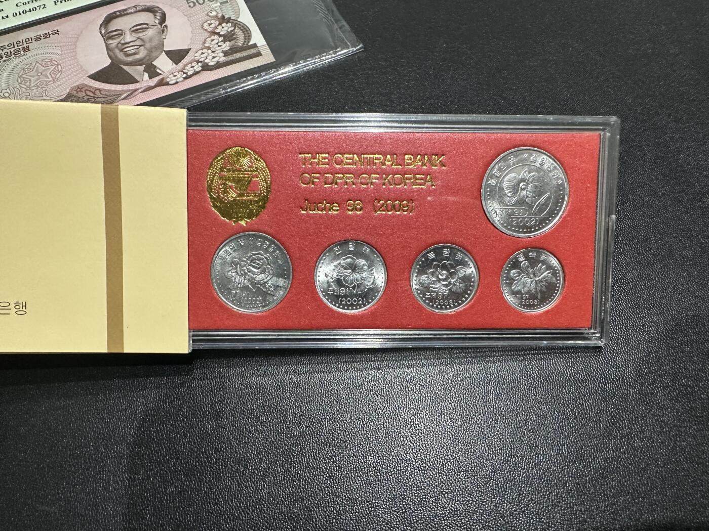 《外钞收藏家》第五百九十六期（精品大拍场）（本平台长期征集拍品、欢迎藏友们联系合作） 2008年朝鲜5000元 TQG评级+2009年朝鲜央行原盒 花卉样币5枚 一起