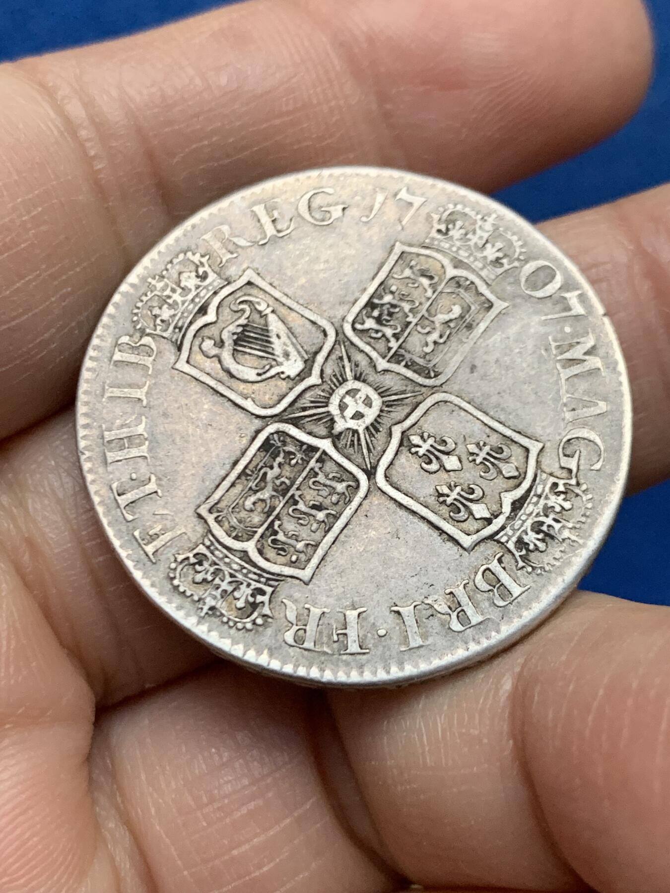 《竞宝斋》第450场 周日，周一，周二  3场连拍 （全场包邮，欢迎送拍） 英国1707年安妮女王半克朗银币 大不列颠首版! 爱丁堡E厂 英格兰苏格兰合并为大不列颠后首版 经典十字盾徽从英苏分盾改成了英苏拼合盾 苏格兰爱丁堡厂开始改生产英格兰制式钱币之时 安妮女王头像威严端庄 图案完整 边铭在位第六年清晰可读 嘴上有个小戳