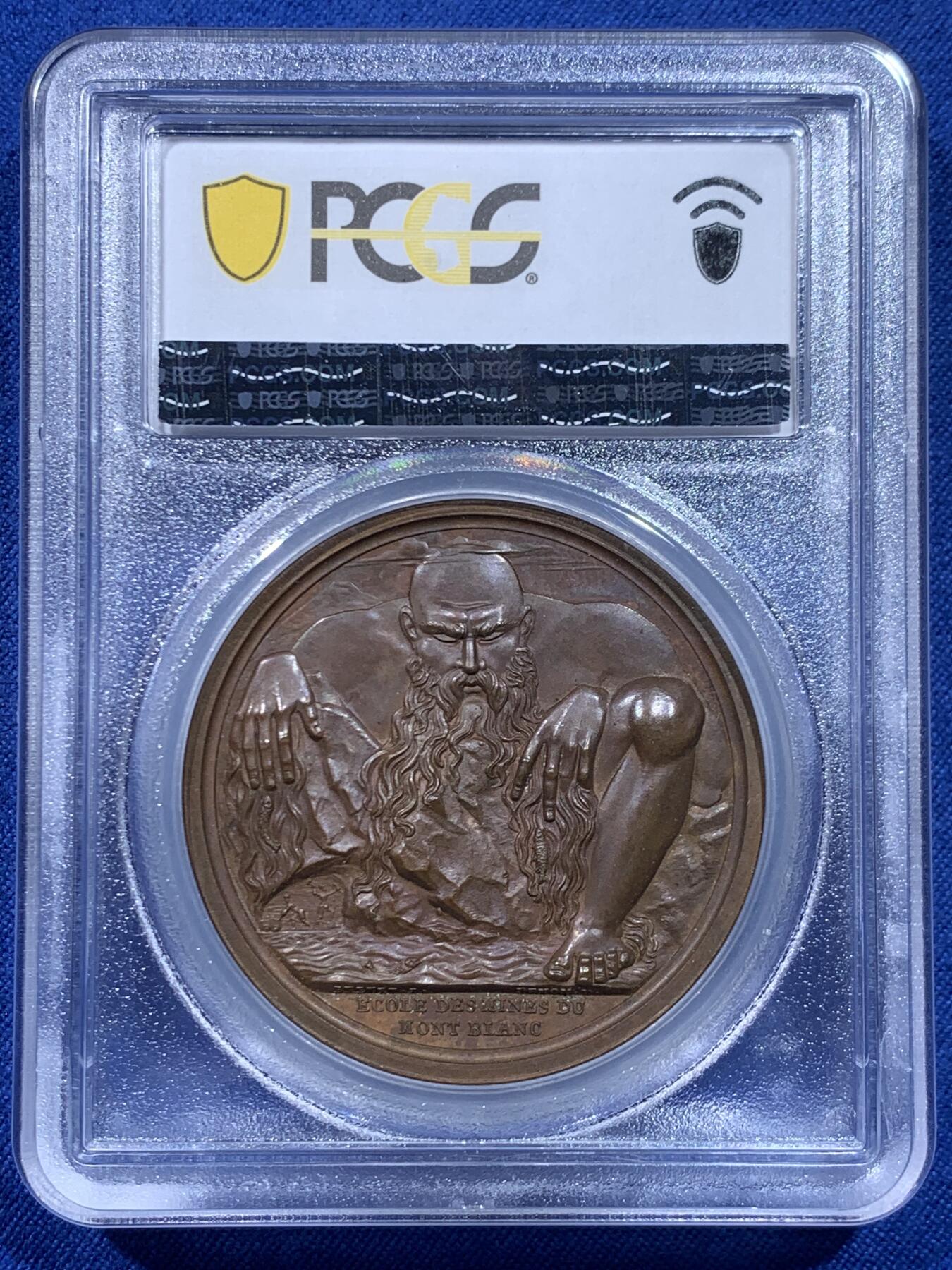 《竞宝斋》第450场 周日，周一，周二  3场连拍 （全场包邮，欢迎送拍） PCGS SP64 亚军分 法国1805年拿破仑一世原铸铜章 拿皇少见头像版 巴黎造币厂紫檀色包浆 勃朗峰拟人化的巨人山神形象，头顶云端，须发缕缕分明，威严充满力量的神明，蹲伏着抬起两名矿工正在工作的巨石，满满细节，脚下是一条流淌的河流，曲折地流淌，可谓拿章系列中画面最富创造力之一，仅一枚65分更高，加厚盒。
