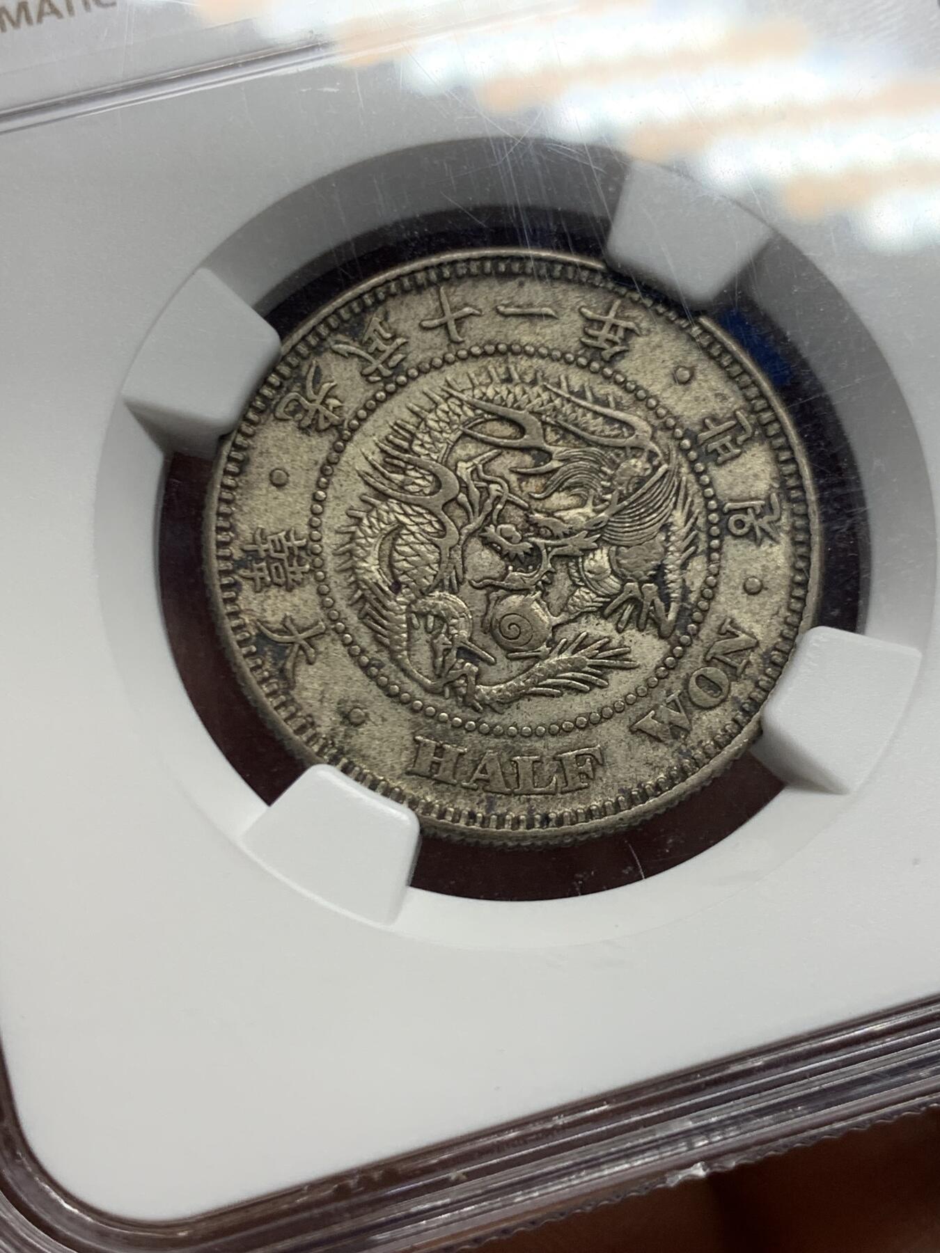 《竞宝斋》第450场 周日，周一，周二  3场连拍 （全场包邮，欢迎送拍） NGC AU53  朝鲜1907年光武十一年半圆银币 十一年稀少年份 原味自然老彩，正面蟠龙戏珠图，龙身盘踞如环，背面上方为“李花章”（五瓣木槿花），下方交叉的桔梗花（左）与李花（右），些许低评。