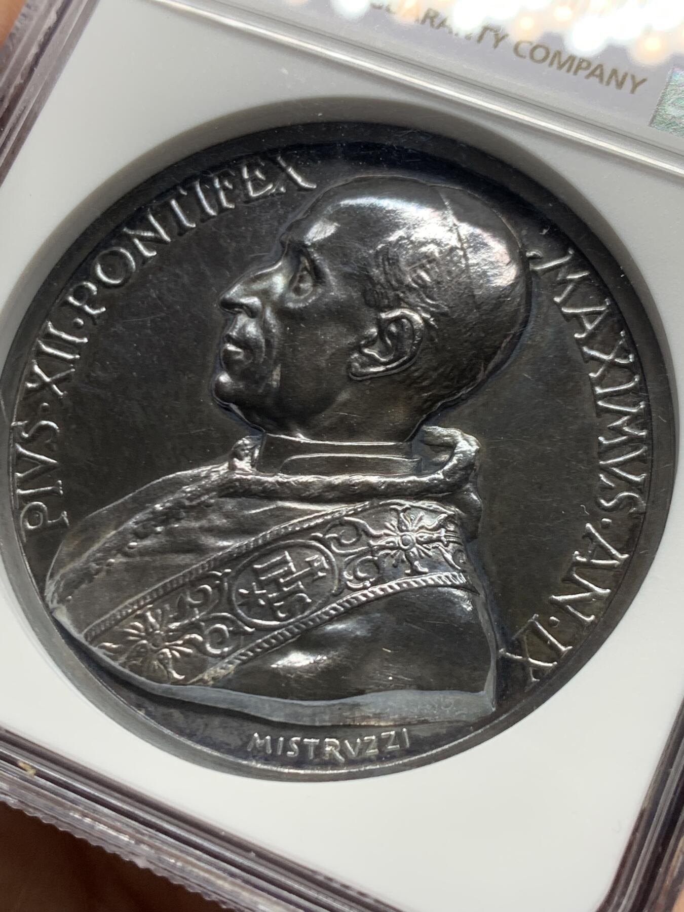 《竞宝斋》第451场 周日，周一，周二  3场连拍 （全场包邮，欢迎送拍） NGC MS62 梵蒂冈庇护十二世银章，背面是当时天主教会推崇的九圣人像，边文拉丁语：已被接入神界的众神们，快来救助人类的危难吧！加厚盒