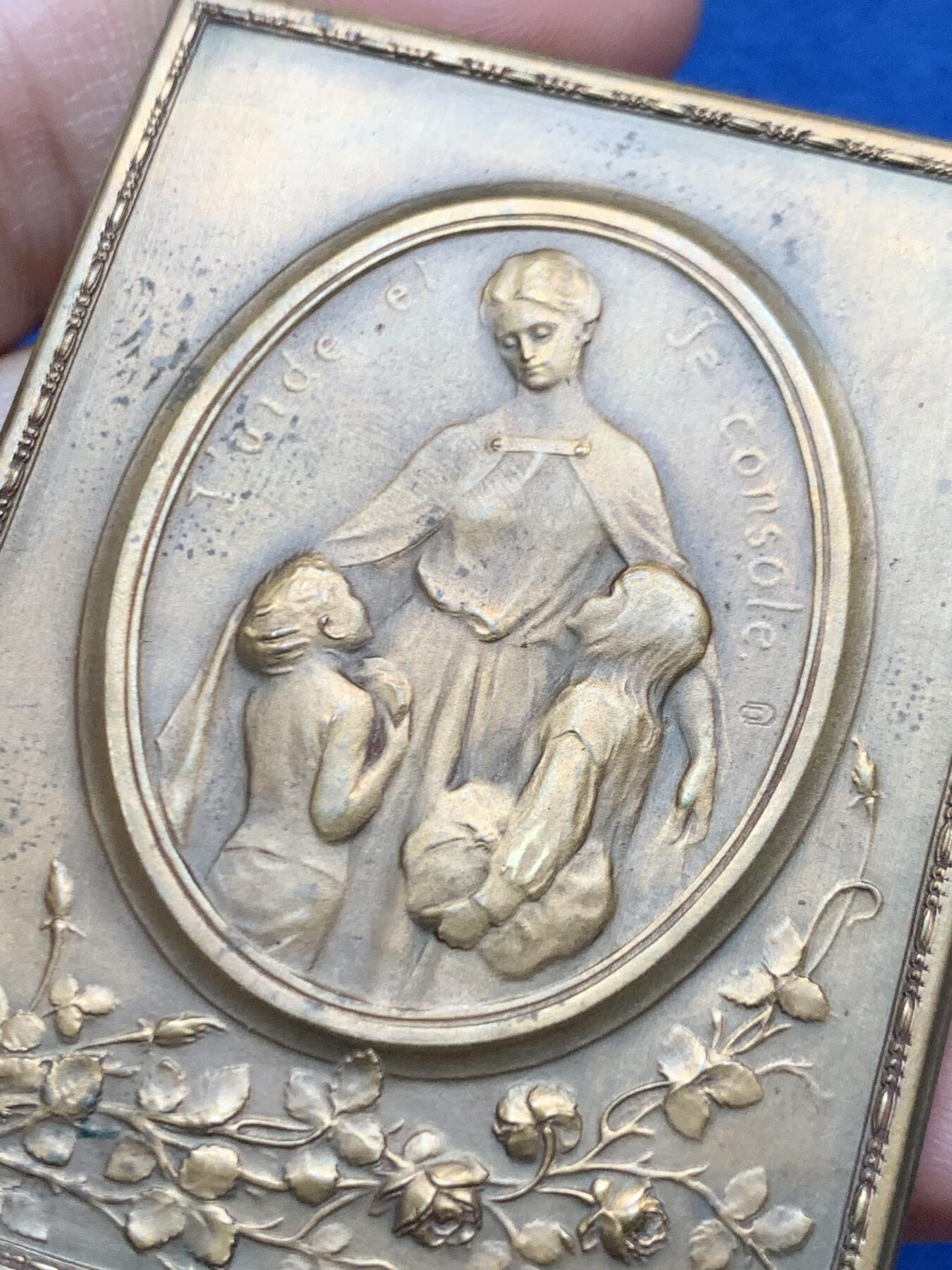 《竞宝斋》第451场 周日，周一，周二  3场连拍 （全场包邮，欢迎送拍） 比利时著名雕刻家：Godefroid Devreese作品-《孤儿之花》艺术奖章，非常漂亮，双面人物雕刻，整体奖章以画框形式展现，极为少见，正面女神展开双臂将儿童拥入怀中，十分暖意。背面一名手提花篮的穿连体短裙的小女儿，手拿花束十分优雅。不可错过。规格：62*46.6mm，重：90.4g