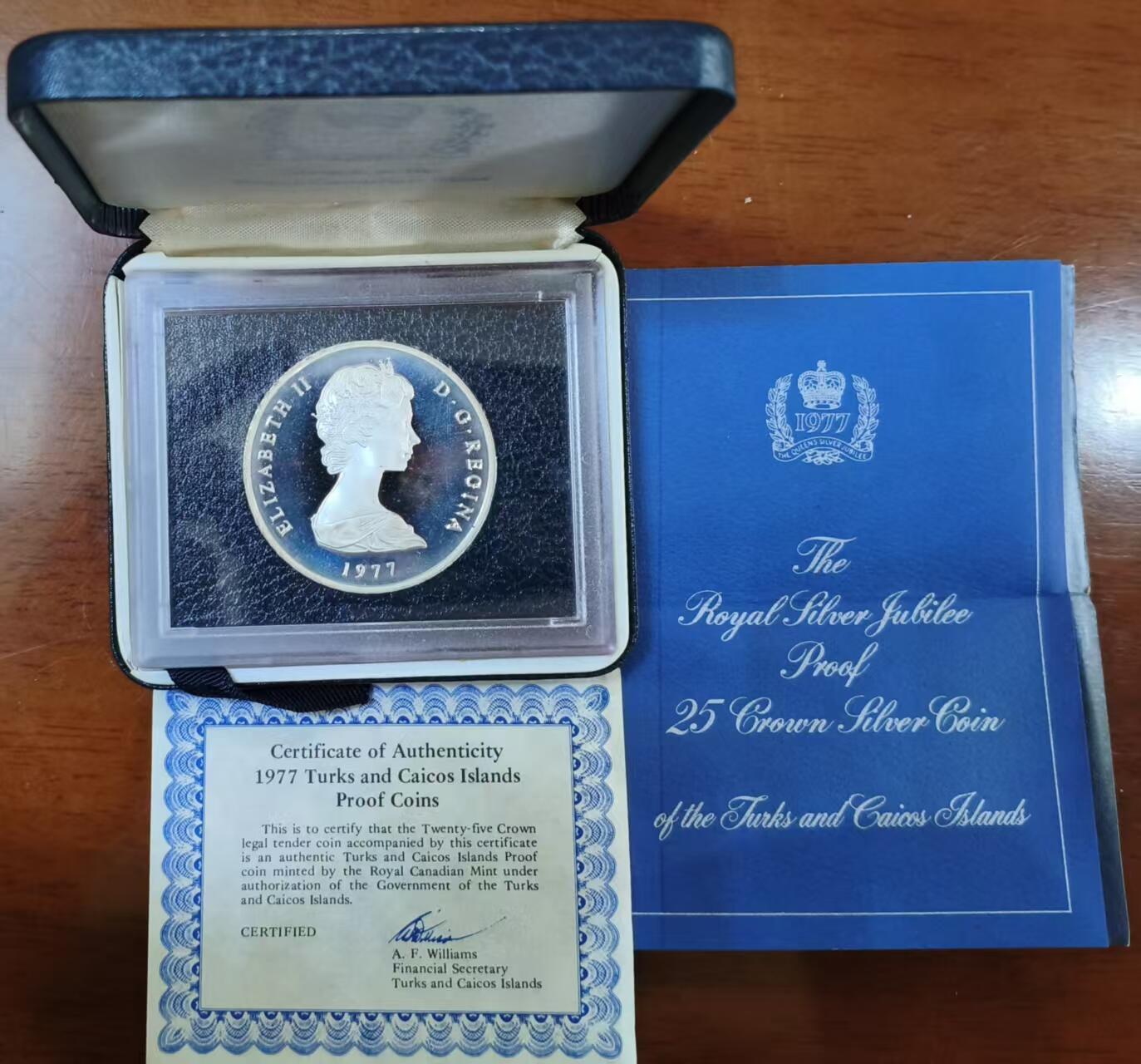 ❤️【币观天下】❤️ 第336期钱币拍卖- 2025.12.26周五晚上6点半场-长期征集拍品 特克斯凯科斯1977年28克朗女王登基银禧大银币 难能可贵的原盒证已经不好找了，额外还有一张蓝色的证书，双证在手天下我有！含纯银40.47克