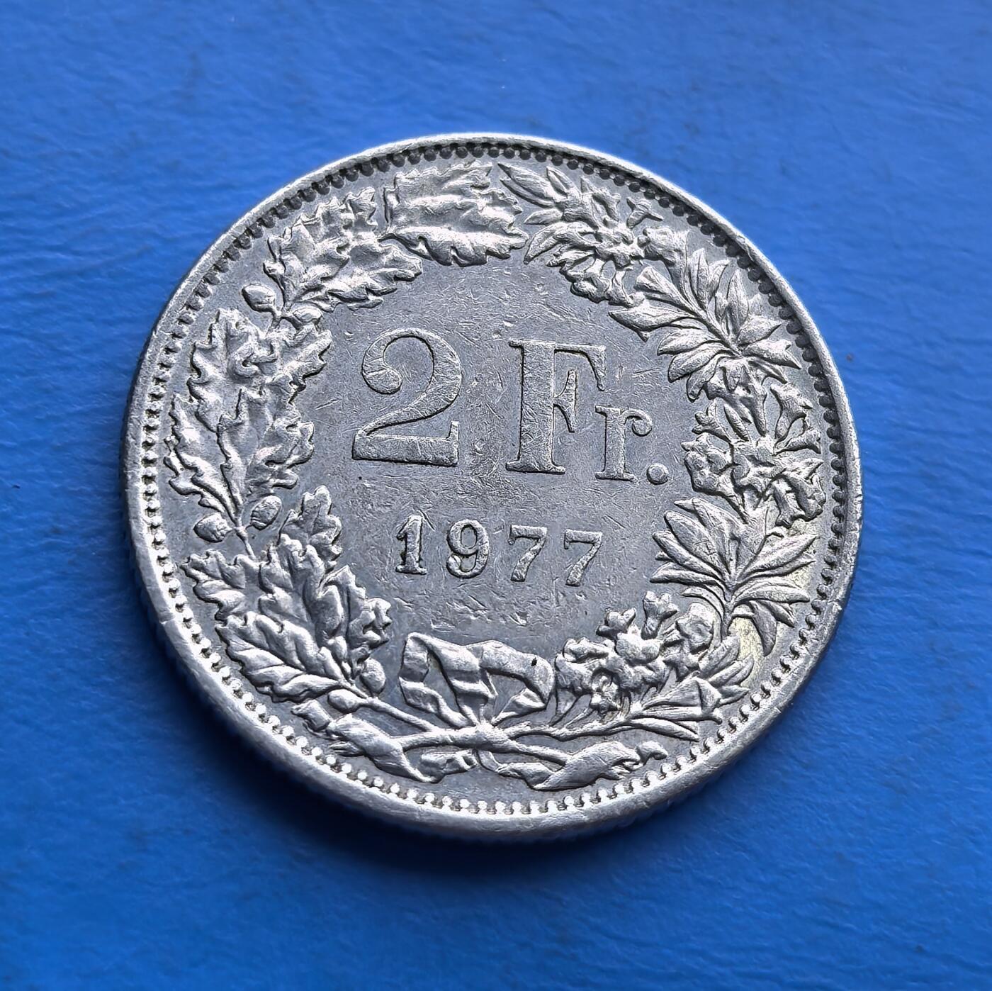 外国优质老铜币高银银币，周六九点倒数截拍，满百包邮，持续收拍 瑞士 1977 年2 法郎，正面 “赫尔维蒂亚” 女神持盾立姿，背面花环环绕币值，延续经典设计。虽为铜镍材质，却承载瑞士中立国文化符号，流通品相凝萃岁月痕迹。