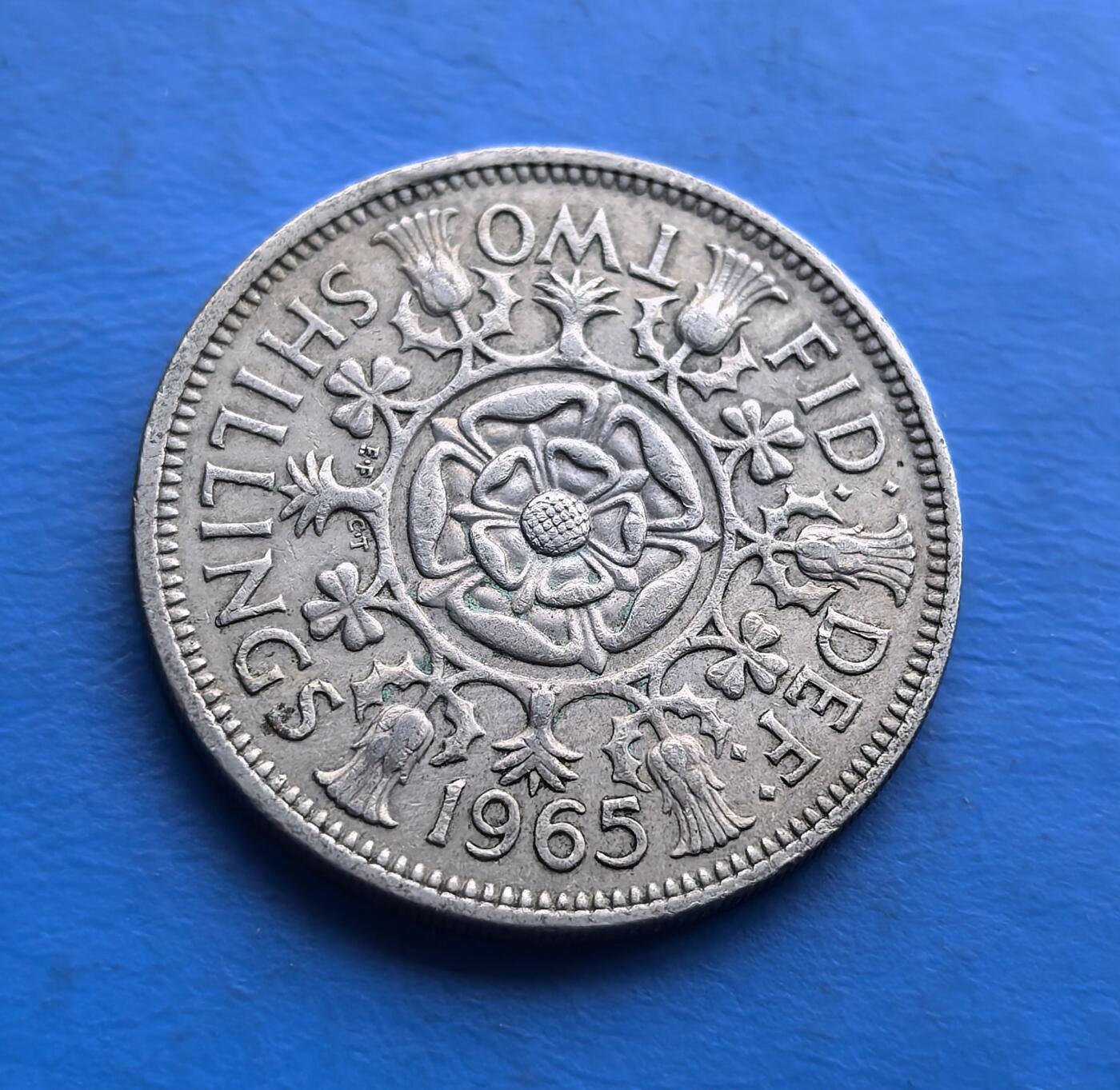 外国优质老铜币高银银币，周六九点倒数截拍，满百包邮，持续收拍 英国1965 年两先令硬币，恰逢货币改革前夕。背面都铎玫瑰、蓟花等图案，凝萃联合王国四族象征；正面年轻女王像，定格王室风华。铜镍材质，流通品相承载 60 年代英伦记忆，是解码英国货币史、触摸 “联合” 符号的亲民标本，适配不列颠文化藏家 。