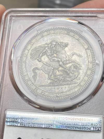 万国钱币拍卖第058期（万国新年大拍） PCGS MS64+ 1819年LIX英国乔治三世马剑克朗大银 英国马剑系列的开山之作 马剑图案由著名的意大利雕刻家Pistrucci设计 在钱币两面皆留下签名 这在当时是难以被接受的（通常只留首字母缩写） 此举也为后来首席雕刻师W.Wyon上位埋下伏笔 此枚无论底板，包浆，还是高点都堪称无可挑剔  一枚乔三马剑的标准器  高分价格越来越看不懂的存在 此次贴脸入手机会切勿错过