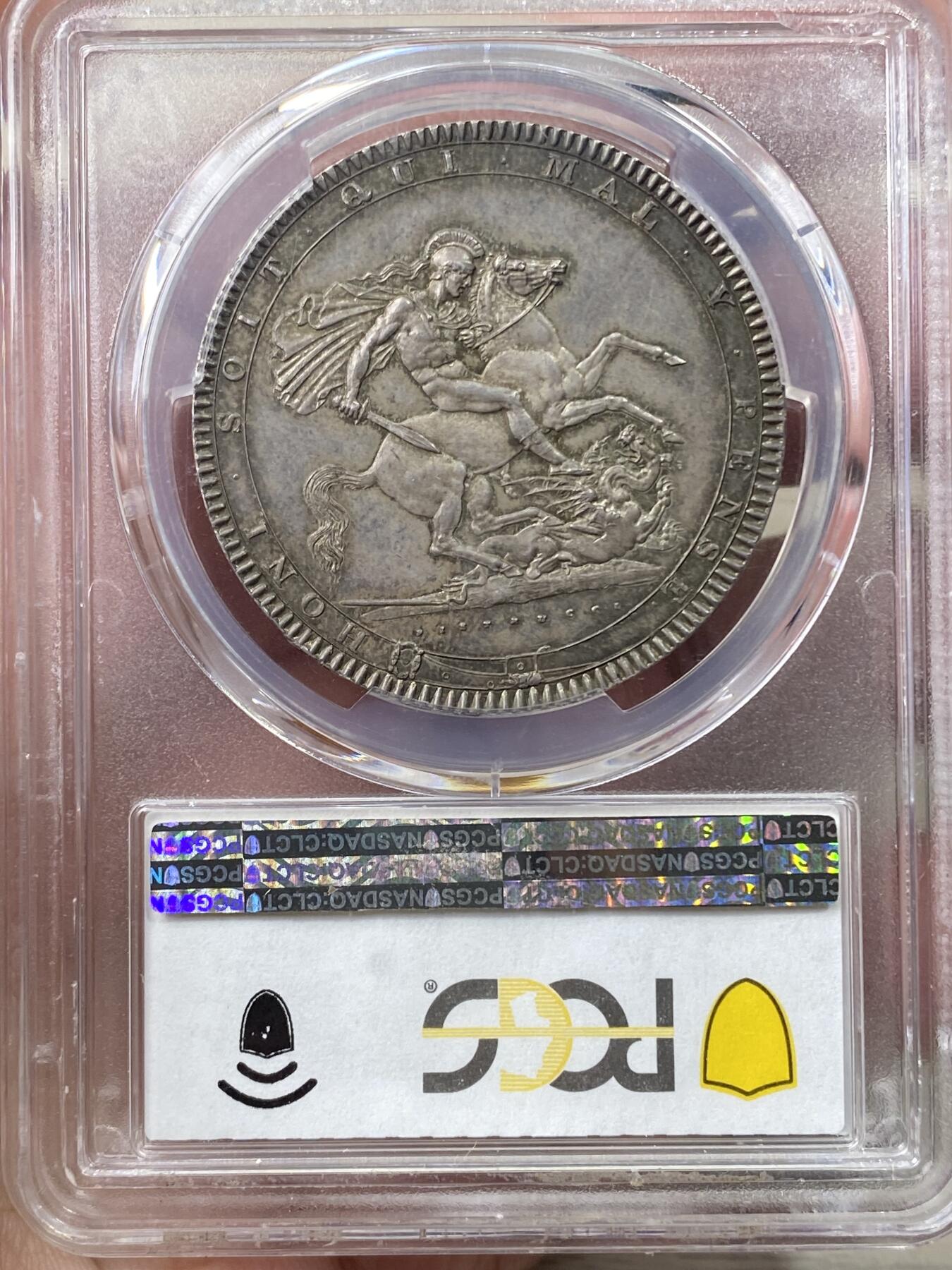 万国钱币拍卖第058期（万国新年大拍） PCGS MS64+ 1819年LIX英国乔治三世马剑克朗大银 英国马剑系列的开山之作 马剑图案由著名的意大利雕刻家Pistrucci设计 在钱币两面皆留下签名 这在当时是难以被接受的（通常只留首字母缩写） 此举也为后来首席雕刻师W.Wyon上位埋下伏笔 此枚无论底板，包浆，还是高点都堪称无可挑剔  一枚乔三马剑的标准器  高分价格越来越看不懂的存在 此次贴脸入手机会切勿错过