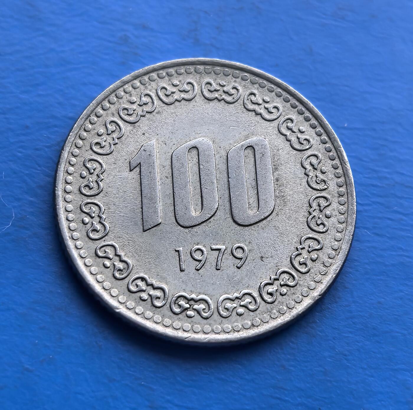 外国优质老铜币高银银币，周六九点倒数截拍，满百包邮，持续收拍 韩国 1979 年100 元硬币，正面镌抗倭名将李舜臣，凝萃民族精神；背面传统花纹环绕币值，尽显东方美学。铜镍材质，流通品相承载 70 年代韩国记忆，是解码韩民族英雄叙事、填补亚洲货币收藏的亲民标的，适配历史迷与世界币藏家 。