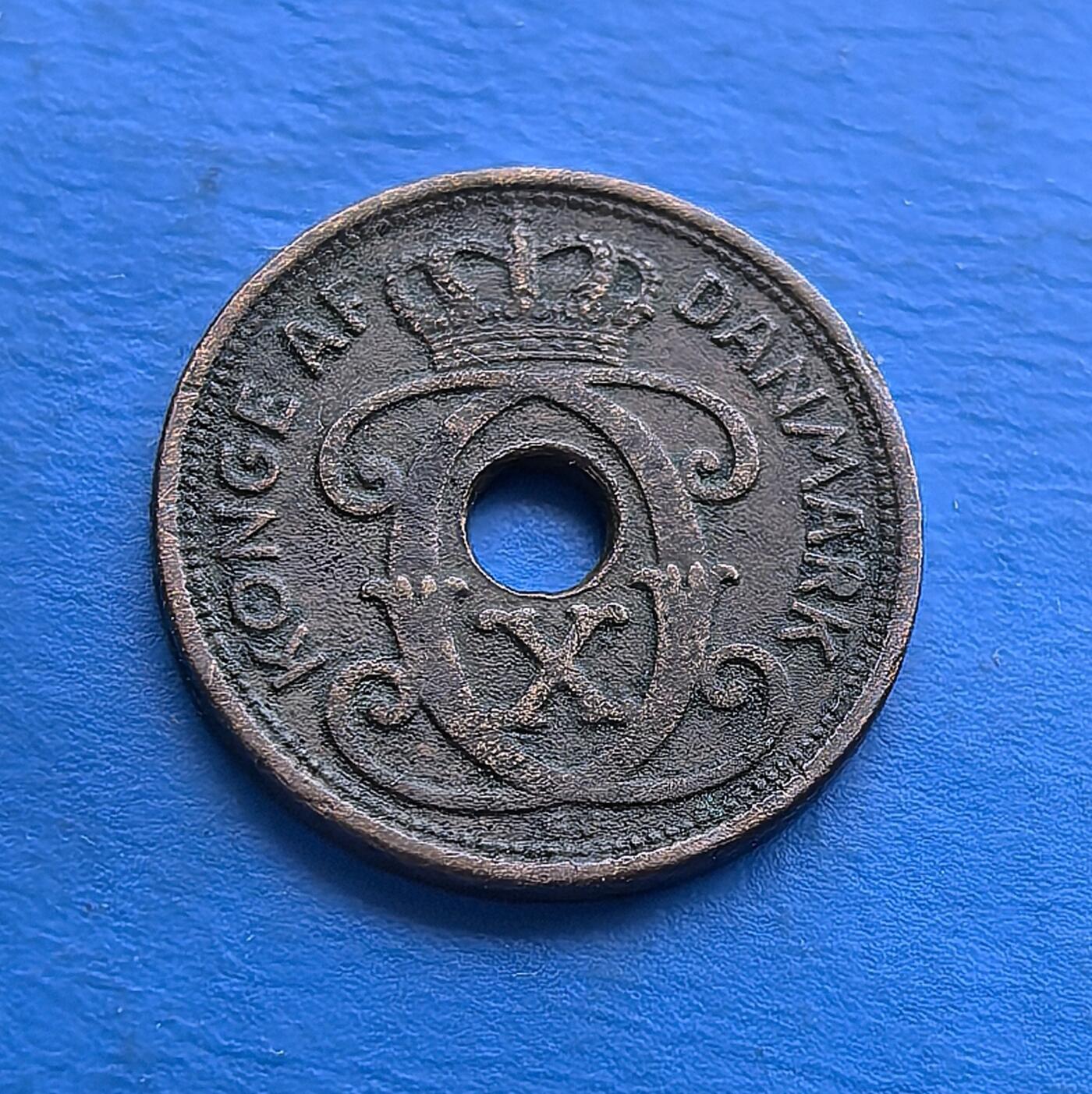 外国优质老铜币高银银币，周六九点倒数截拍，满百包邮，持续收拍 丹麦1927年1 欧尔青铜圆孔币，发行于克里斯蒂安十世统治期（二战前和平阶段）。正面饰王室花押与皇冠，背面镌 “DANMARK”、年份及面值，圆孔设计独特。青铜包浆厚重，见证战前丹麦货币工艺，是北欧君主制钱币收藏的经典标的，承载早期王室货币的历史韵味 。