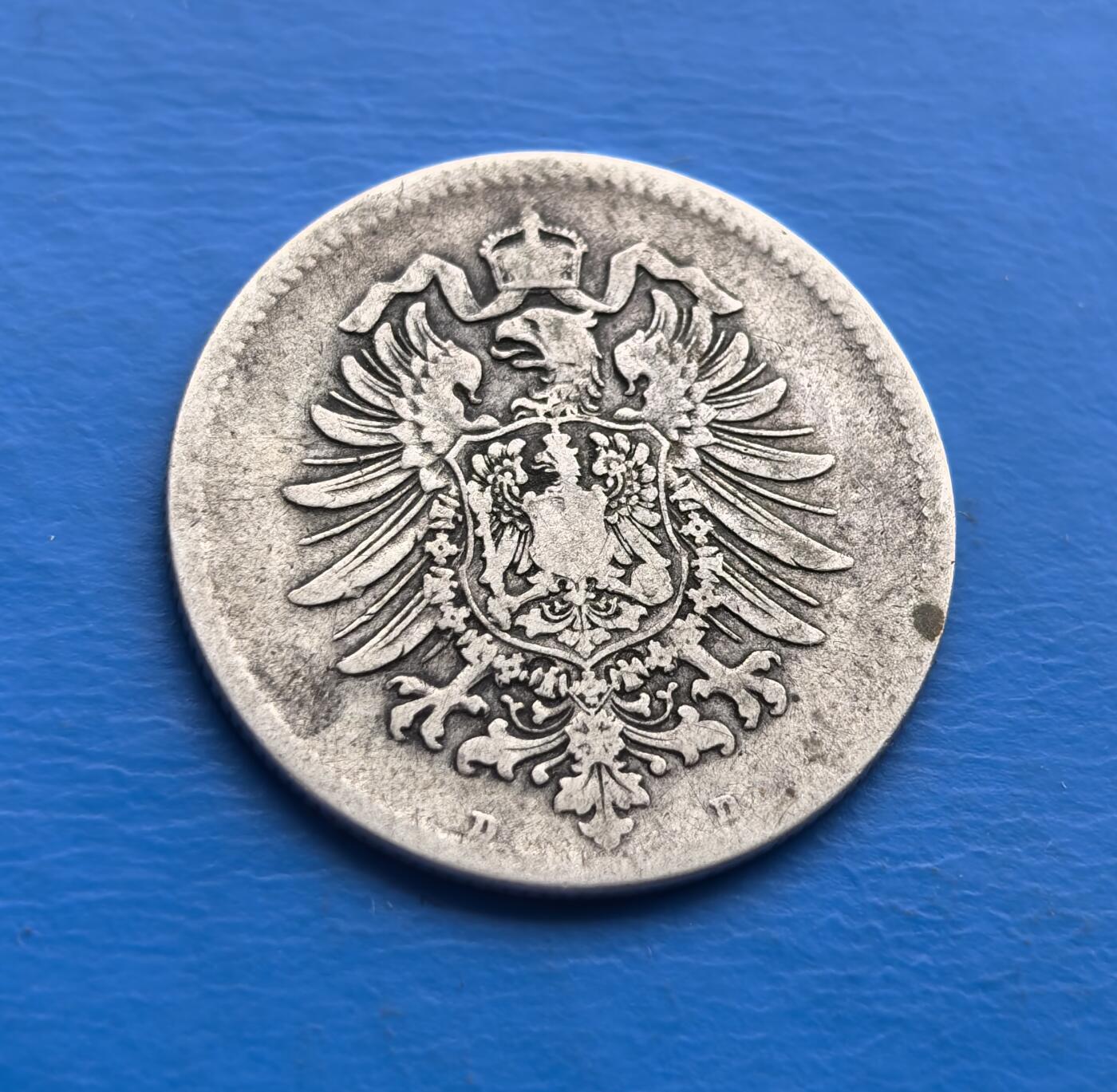 外国优质老铜币高银银币，周六九点倒数截拍，满百包邮，持续收拍 德意志帝国1881 年 1 马克银币，诞生于德国统一后第十年（威廉一世统治期），见证帝国初创历程。正面双首鹰徽（传承皇权，象征统一），背面橡树叶环（日耳曼精神符号），“DEUTSCHES REICH” 烙刻国家身份。90% 纯银铸就，百年包浆凝萃岁月痕迹。作为帝国早期流通币，承载德国统一史诗，设计融合国徽与民族元素，存世随岁月递减。是解码德意志帝国肇始、填补欧洲钱币收藏的珍贵标本，历史厚重与艺术价