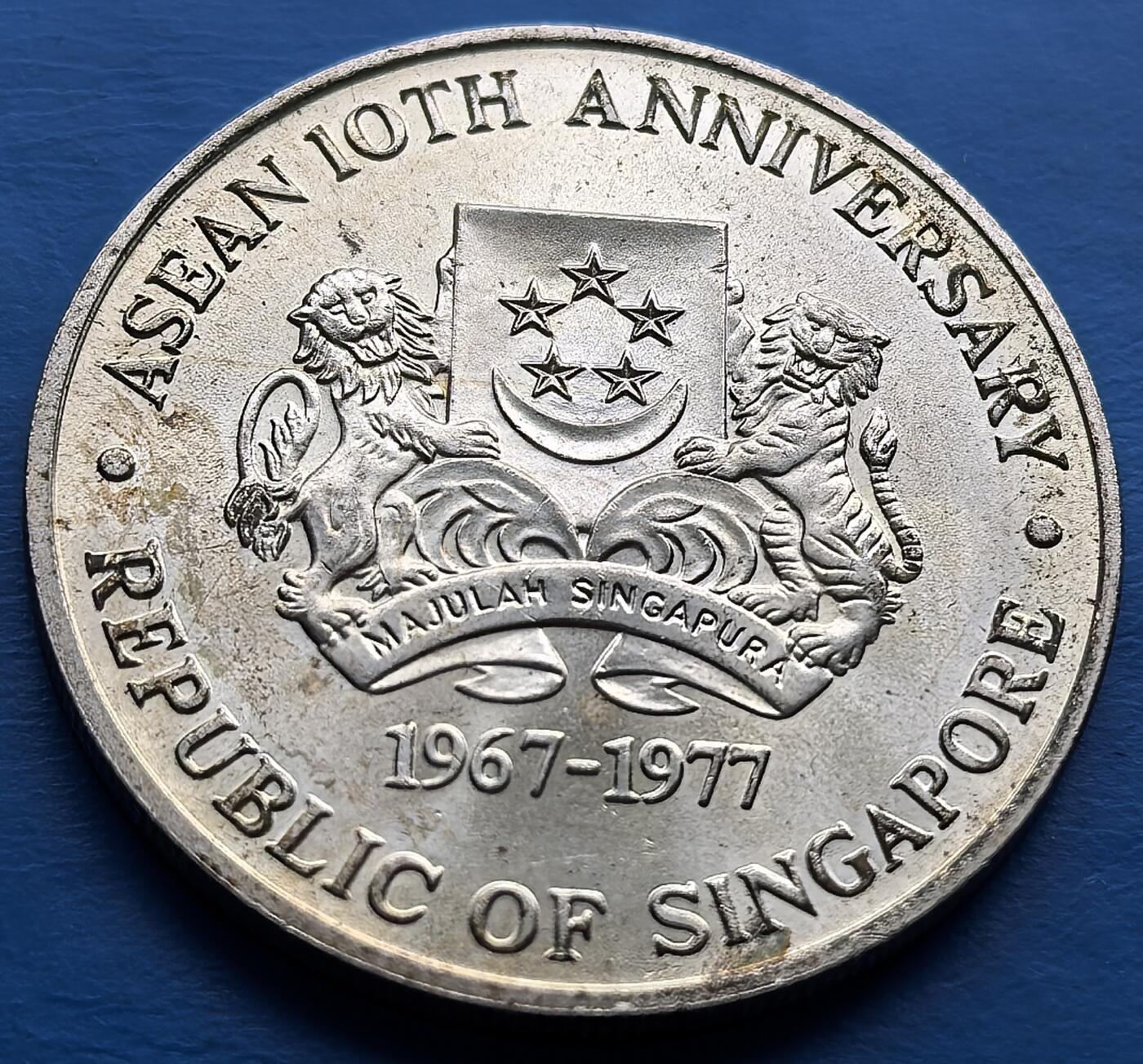 外国优质老铜币高银银币，周六九点倒数截拍，满百包邮，持续收拍 新加坡 1977 年东盟成立 10 周年纪念银币，面值 10 元。背面 “hands 环绕地图” 象征东盟团结，正面铸新加坡国徽，铭记 1967 - 1977 年东盟发展里程碑。题材独特，设计寓意深刻，见证区域合作起点，银币材质更添收藏价值，是东盟及新加坡钱币收藏的稀缺标的 。