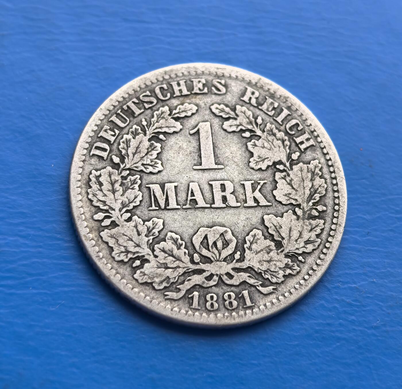 外国优质老铜币高银银币，周六九点倒数截拍，满百包邮，持续收拍 德意志帝国1881 年 1 马克银币，诞生于德国统一后第十年（威廉一世统治期），见证帝国初创历程。正面双首鹰徽（传承皇权，象征统一），背面橡树叶环（日耳曼精神符号），“DEUTSCHES REICH” 烙刻国家身份。90% 纯银铸就，百年包浆凝萃岁月痕迹。作为帝国早期流通币，承载德国统一史诗，设计融合国徽与民族元素，存世随岁月递减。是解码德意志帝国肇始、填补欧洲钱币收藏的珍贵标本，历史厚重与艺术价