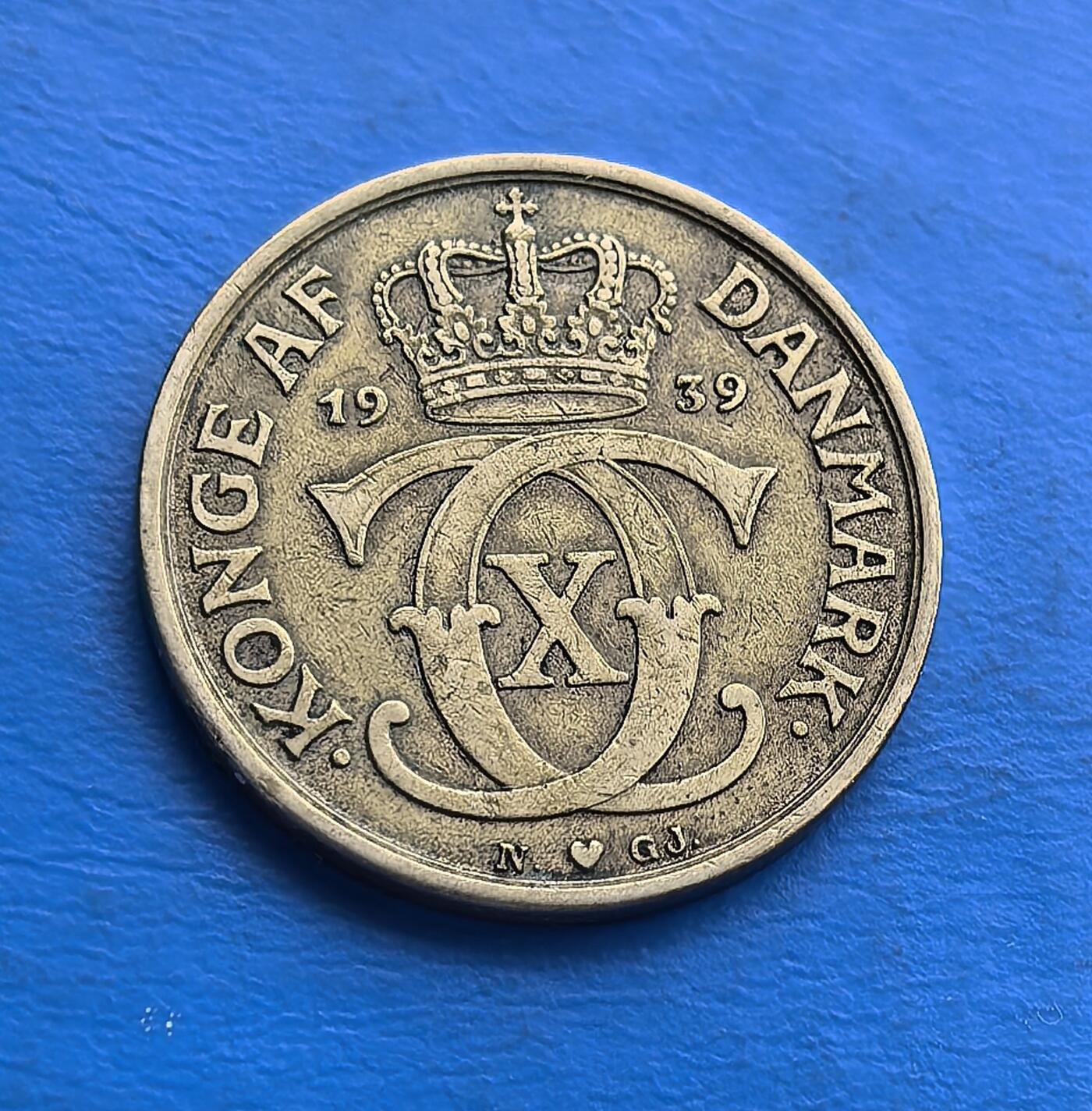 外国优质老铜币高银银币，周六九点倒数截拍，满百包邮，持续收拍 丹麦 1939 年1 克朗，铸于二战前夜，克里斯蒂安十世统治期。正面皇冠、背面君主花押（CXC），尽显王室符号。铜镍包浆藏岁月，见证北欧战前宁静与王权传承。北欧铸工精细，承载丹麦君主制脉络，是二战前夜货币标本，亲民门槛，适配王室及欧洲币藏，解码战前北欧历史 。