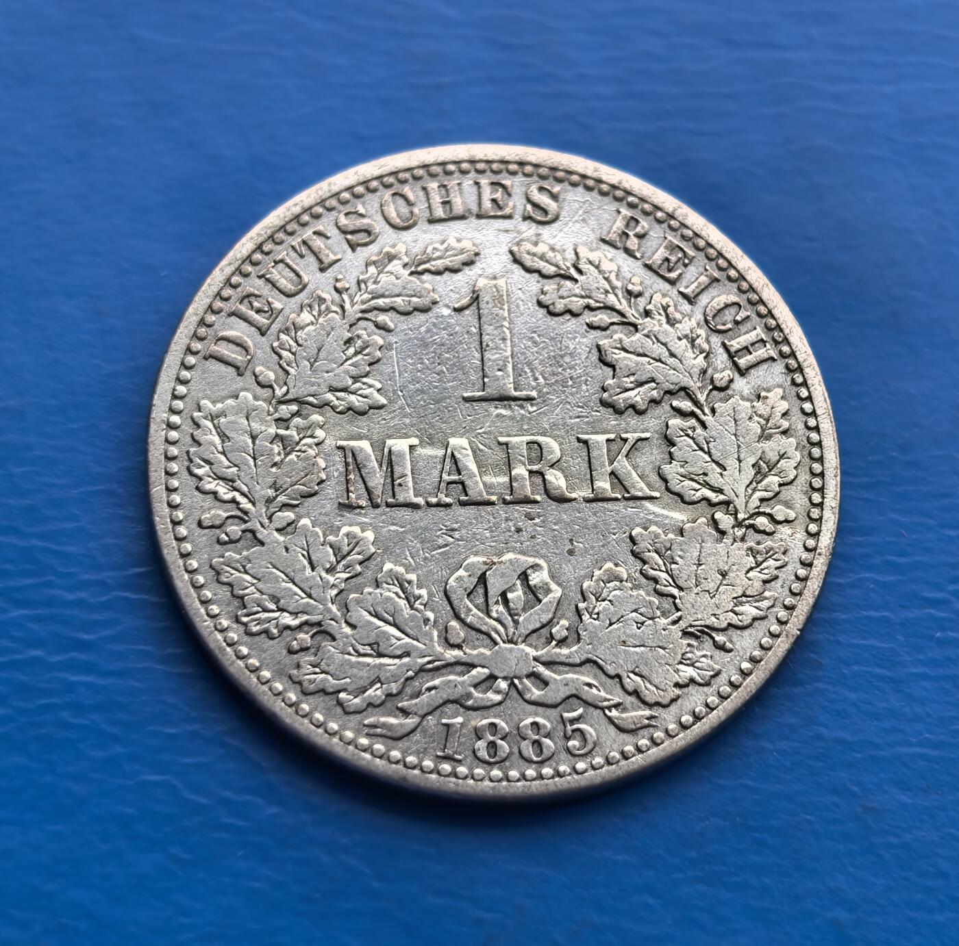 外国优质老铜币高银银币，周六九点倒数截拍，满百包邮，持续收拍 德意志帝国1885 年 1 马克银币，诞生于德国统一后第 14 年（威廉一世统治期），见证帝国初创。正面双首鹰徽（传承皇权，象征统一），背面橡树叶环（日耳曼精神符号），“DEUTSCHES REICH” 烙刻国家身份。90% 纯银铸就，百年包浆凝萃岁月痕迹。作为帝国早期流通币，承载德国统一历史，设计融合国徽与民族元素，存世随岁月递减。是解码德意志帝国肇始、填补欧洲钱币收藏的珍贵标本，历史厚重与艺术